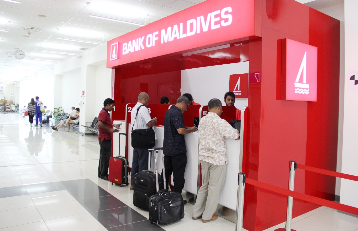 އެއާޕޯޓުގައި ހުންނަ ބީއެމްއެލްގެ ޑޮލަރު ކައުންޓަރުން ބަޔަކު ޑޮލަރު ގަންނަނީ.-- ފޮޓޯ: ބީއެމްއެލް