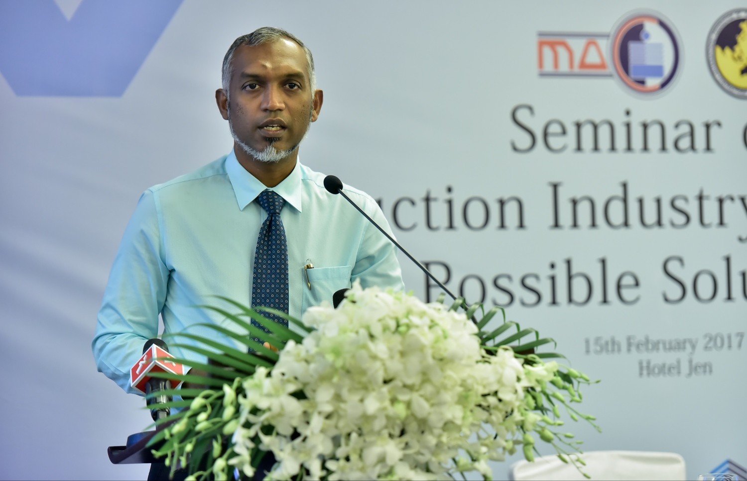 މާލެ: ފެބްރުއަރީ 15، 2017: މޯލްޑިވްސް އެސޯސިއޭޝަން އޮފް ކޮންސްޓްރަކްޝަން އިންޑަސްޓްރީ (މަސީ) ގެ ފަރާތުން، އިމާރާތް ކުރުމަށް ހުރި ދަތިތަކާ ބެހޭ ގޮތުން މަޝްވަރާކޮށް ހައްލެއް ހޯދުމަށް ހޮޓެލް ޖެންގައި ބޭއްވި ސެމިިނާގައި ހައުސިން މިނިސްޓަރު މުހައްމަދު މުއިއްޒު ވާހަކަ ދައްކަވަނީ.-- ފޮޓޯ: ނިޝާން އަލީ/ މިހާރު