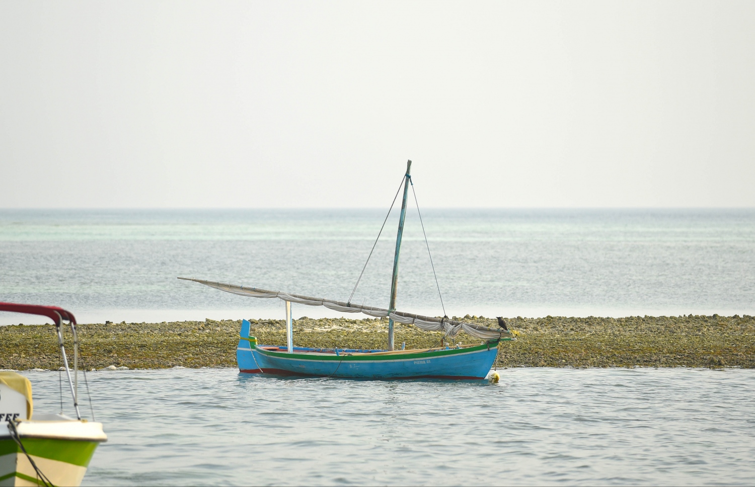 ހއ. މޮޅަދޫ ފަޅުގައި އަޅާފައި އޮތް ދޯންޏެއް އަދި ފަޅު ތެރެއިން ހިކިފައި އޮތް ވެލިގަނޑެއް. -- ފޮޓޯ: އަބްދުﷲ އައުރާފް/މިހާރު