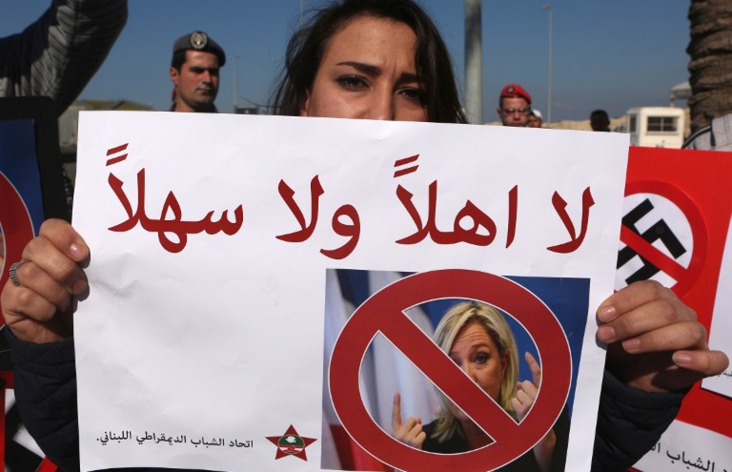 ފްރާންސްގެ ރިޔާސީ ކެންޑިޑޭޓަށް މަރުހަބާ ނުކިޔާނެ ކަމަށް ބުނެ ލުބުނާނުގެ އަންހެނަކު ބޭރޫތުގައި ބޯޑެއް ހިފައިގެން. --ފޮޓޯ:އޭއެފްޕީ