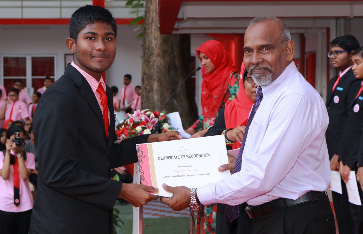 މާލެ: ފެބްރުއަރީ 28، 2017- އިސްކަންދަރު ސްކޫލުގެ ޕްރިފެކްޓް ބޯޑާއި ކްލަބުތަކުގެ މަގާމުތަކަށް ހޮވުނު ދަރިވަރުން ހުވާކުރުމަށް ބޭއްވި ރަސްމިއްޔާތުގައި އެޑިއުކޭޝަން މިނިސްޓްރީގެ ސީނިއާ ޕޮލިސީ އެގްޒެކްޓިވް އިބްރާހިމް އިސްމައިލް (ކ)، ދަރިވަރަކަށް ސެޓިފިކެޓް ހަވާލު ކޮށްދެއްވަނީ.---ފޮޓޯ: އިސްކަންދަރު ސްކޫލް