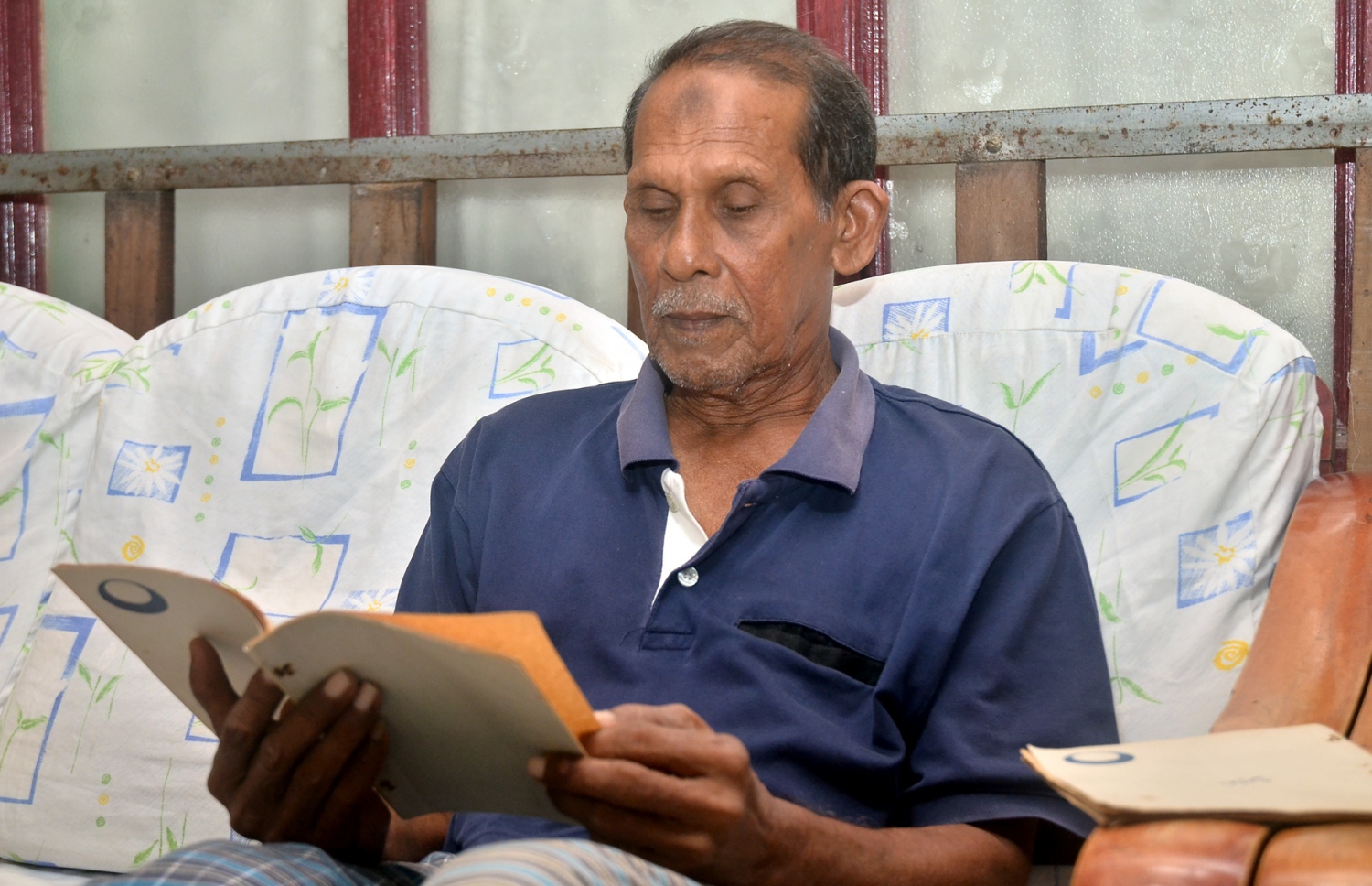 މަދަހަ ކިޔާ ރީތި އަޑެއްގެ ގޮތުގައި މަޝްހޫރުވި އިސްމާއީލް މޫސާ، އޭނާގެ ގޭގެ ސިޓީން ރޫމްގައި އިނދެ މަދަހަ ފޮތެއް ކިޔަނީ. --ފޮޓޯ އަހްމަދު އަބްދުﷲ ސައީދު/މިހާރު