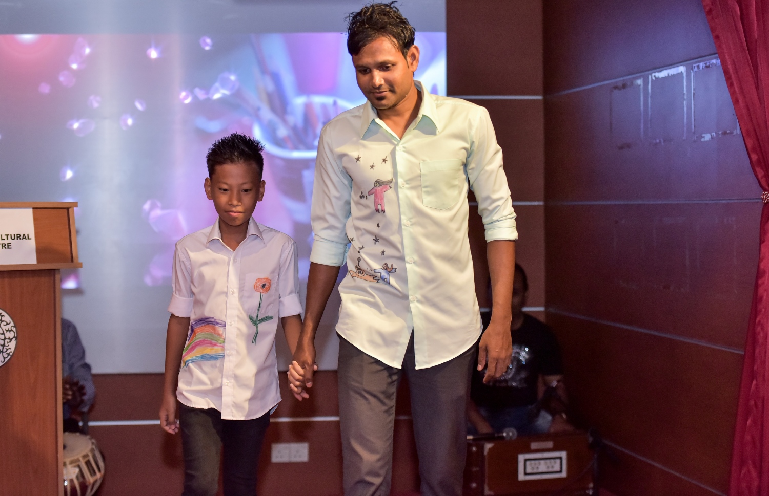 މާލެ: މާޗް 6، 2017: ސެންގެ ކުދިން ތައްޔާރުކޮށްފައިވާ ޑިޒައިނެއް ހިމަނައިގެން ނާޒިޔާ ފަހާފައިވާ ހެދުމުގައި ފުޓުބޯޅަ ކުޅުންތެރިޔާ ޝިފާން (ކ) ދަރިވަރަކާއެކު ރޭމްޕުގައި ހިނގާލަނީ-- ފޮޓޯ: ނިޝާން އަލީ/ މިހާރު