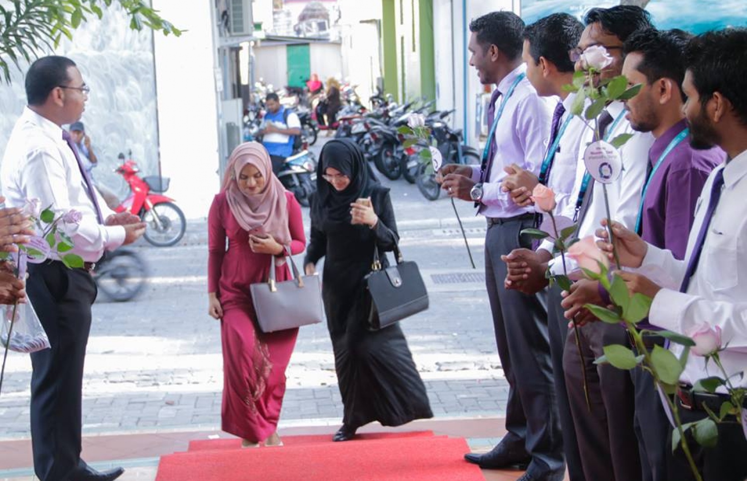 މާލެ: މާޗް 8، 2017: ބައިނަލް އަގްވާމީ އަންހެނުންގެ ދުވަސް ފާހަގަ ކުރުމުގެ ގޮތުން މޯލްޑިވްސް އިންލެންޑް ރެވެނިއު އޮތޯރިޓީ (މީރާ)ގެ އަންހެން މުވައްޒަފުން ގައުމީ ހެދުމުގައި އޮފީހަށް ވަންނަ އިރު، ފިރިހެން މުވައްޒަފުން އެކަނބަލުންނަށް މަރުހަބާ ކިޔަނީ.-- ފޮޓޯ: މީރާ