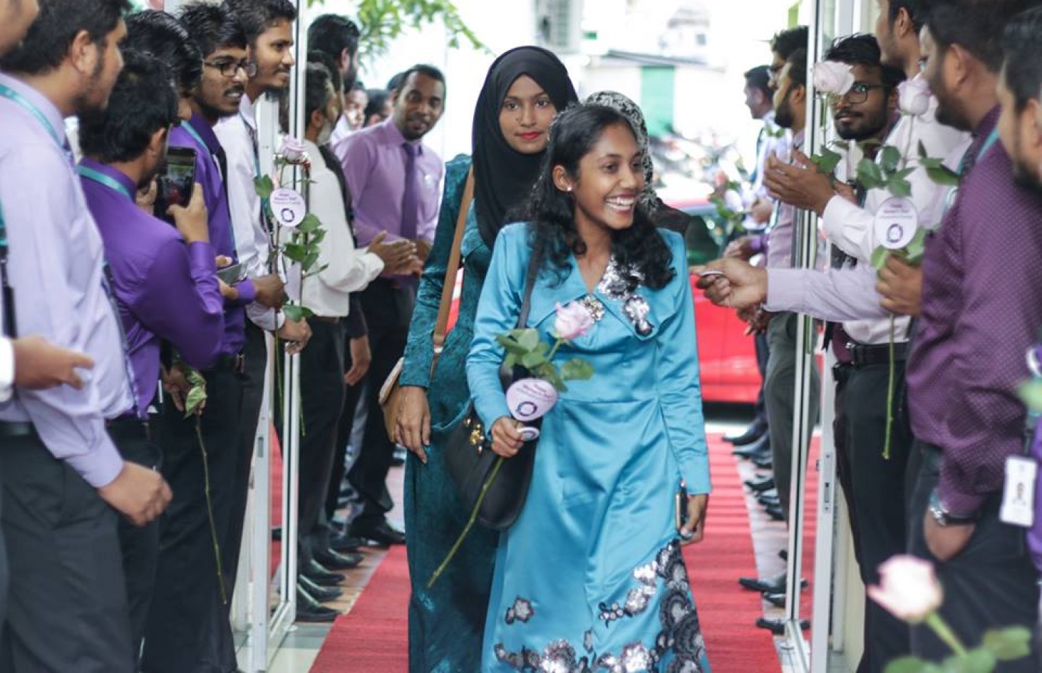 މާލެ: މާޗް 8، 2017: ބައިނަލް އަގްވާމީ އަންހެނުންގެ ދުވަސް ފާހަގަ ކުރުމުގެ ގޮތުން މޯލްޑިވްސް އިންލެންޑް ރެވެނިއު އޮތޯރިޓީ (މީރާ)ގެ އަންހެން މުވައްޒަފުން ގައުމީ ހެދުމުގައި އޮފީހަށް ވަންނަ އިރު، ފިރިހެން މުވައްޒަފުން އެކަނބަލުންނަށް މަރުހަބާ ކިޔަނީ.-- ފޮޓޯ: މީރާ