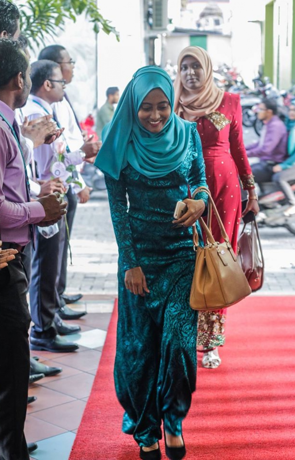 މާލެ: މާޗް 8، 2017: ބައިނަލް އަގްވާމީ އަންހެނުންގެ ދުވަސް ފާހަގަ ކުރުމުގެ ގޮތުން މޯލްޑިވްސް އިންލެންޑް ރެވެނިއު އޮތޯރިޓީ (މީރާ)ގެ އަންހެން މުވައްޒަފުން ގައުމީ ހެދުމުގައި އޮފީހަށް ވަންނަ އިރު، ފިރިހެން މުވައްޒަފުން އެކަނބަލުންނަށް މަރުހަބާ ކިޔަނީ.-- ފޮޓޯ: މީރާ