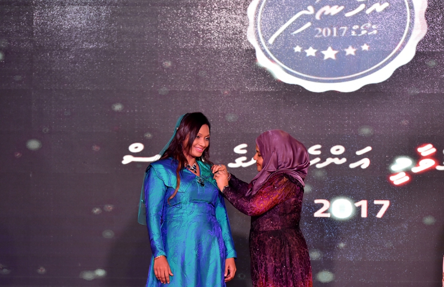 މާލެ: މާޗް 8، 2017: ބައިނަލްއަގުވާމީ އަންހެނުންގެ ދުވަސް ފާހަގަކުރަން ދަރުބާރުގޭގައި ބޭއްވި ޖަލްސާއެއްގައި ރެހެނދި އެވޯޑް ލިބުނު ކަނބަލަކަށް ރައީސް ޔާމީންގެ އަނބިކަނބަލުން ފާތުމަތު އިބްރާހިމް، ބެޖެއް ހަވާލުކޮށްދެއްވަނީ.-- ފޮޓޯ: ރައީސް އޮފީސް