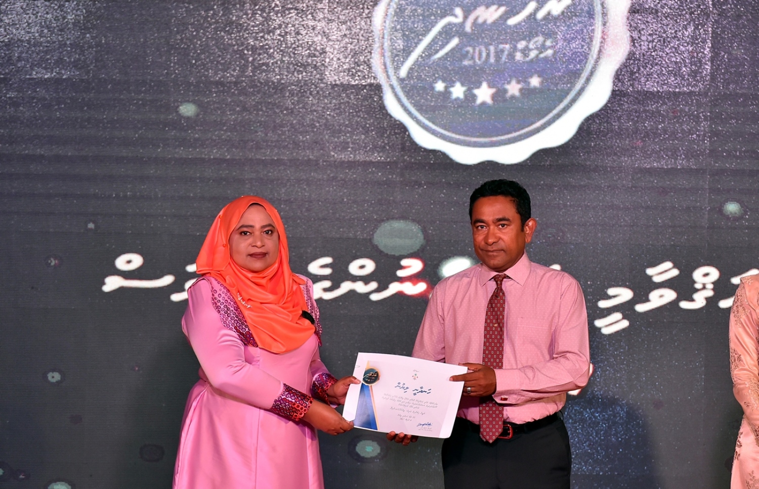 މާލެ: މާޗް 8، 2017: ބައިނަލްއަގުވާމީ އަންހެނުންގެ ދުވަސް ފާހަގަކުރަން ދަރުބާރުގޭގައި ބޭއްވި ޖަލްސާއެއްގައި ރެހެނދި އެވޯޑް ލިބުނު ކަނބަލަކަށް ރައީސް ޔާމީން، ހަނދާނީ ލިޔުން ހަވާލުކޮށްދެއްވަނީ.-- ފޮޓޯ: ރައީސް އޮފީސް