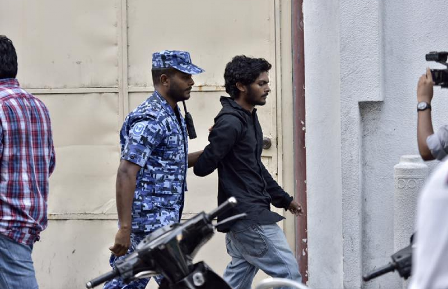 ޖުމްހޫރީ ޕާޓީގެ ލީޑަރު ގާސިމް އިބްރާހިމް ހައްޔަރުކޮށް، ބަންދުގެ މުއްދަތު އިތުރުކުރުމަށް ކޯޓަށް ހާޒިރުކުރުމާ ދިމާކޮށް މަގުމައްޗަށް އެއްވި މީހުން ފަހަތަށް ޖައްސައި މީހަކު ބެލުމުގެ ދަށަށް ގެންދަނީ. -- ފޮޓޯ: ނިޝާން އަލީ/މިހާރު