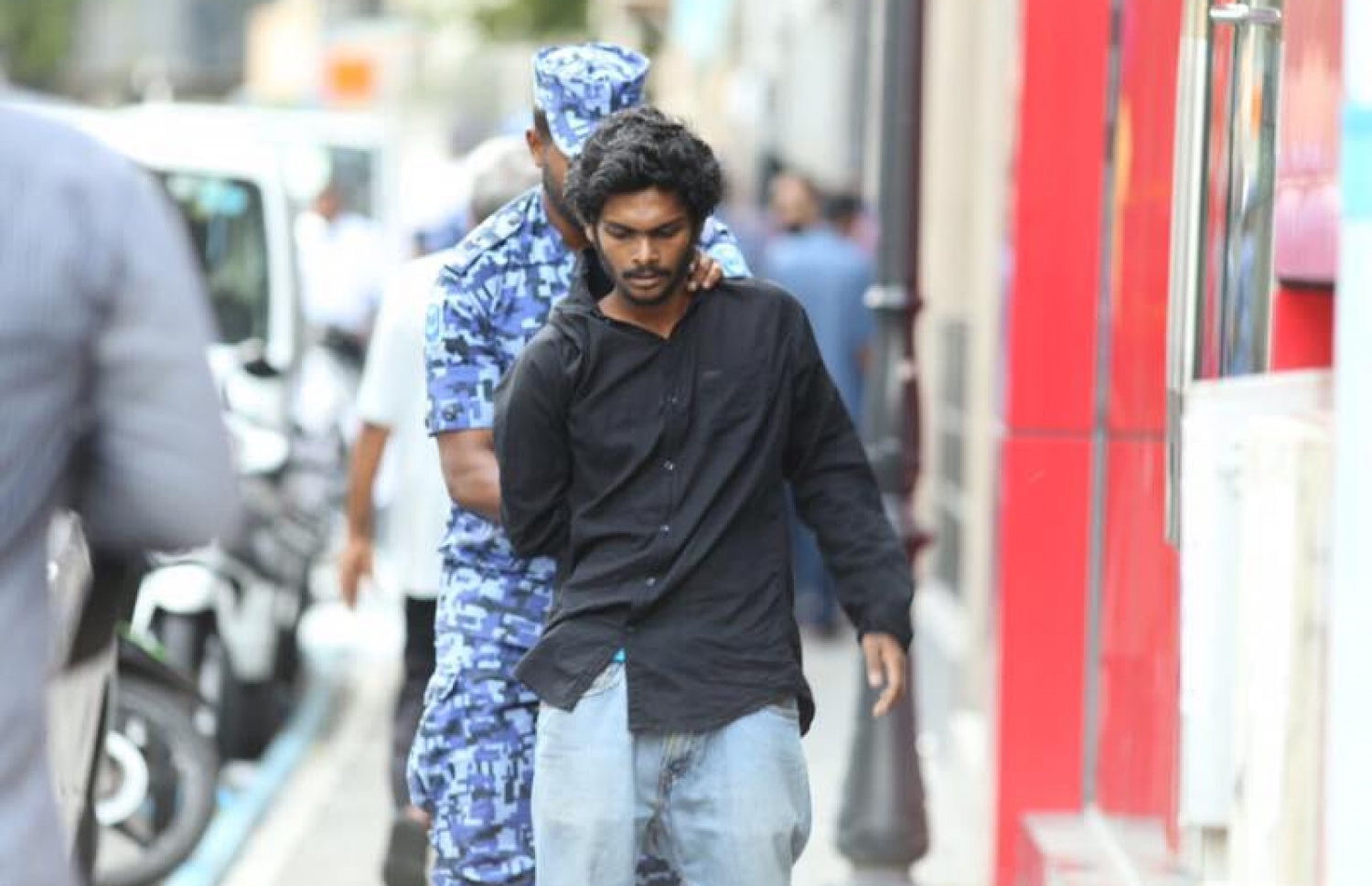 ޖުމްހޫރީ ޕާޓީގެ ލީޑަރު ގާސިމް އިބްރާހިމް ހައްޔަރުކޮށް، ބަންދުގެ މުއްދަތު އިތުރުކުރުމަށް ކޯޓަށް ހާޒިރުކުރުމާ ދިމާކޮށް މަގުމައްޗަށް އެއްވި މީހުން ފަހަތަށް ޖައްސައި މީހަކު ފުލުހުންގެ ބެލުމުގެ ދަށަށް ގެންދަނީ. -- ފޮޓޯ: ނިޝާން އަލީ/މިހާރު