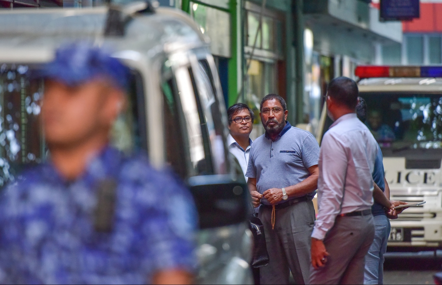 ގާސިމްގެ އޮފީސް ފުލުހުން ފާސްކުރަމުން ދިޔައިރު އޭނާ އޮފީހުން ބޭރުގައި: ގާސިމްގެ މައްޗަށް ތުހުމަތުކުރި ރިޝްވަތުގެ މައްސަލައިގެ ތަހުގީގު ވަނީ ފަށާފައި. --ފޮޓޯ: ހުސެއިން ވަހީދު/މިހާރު