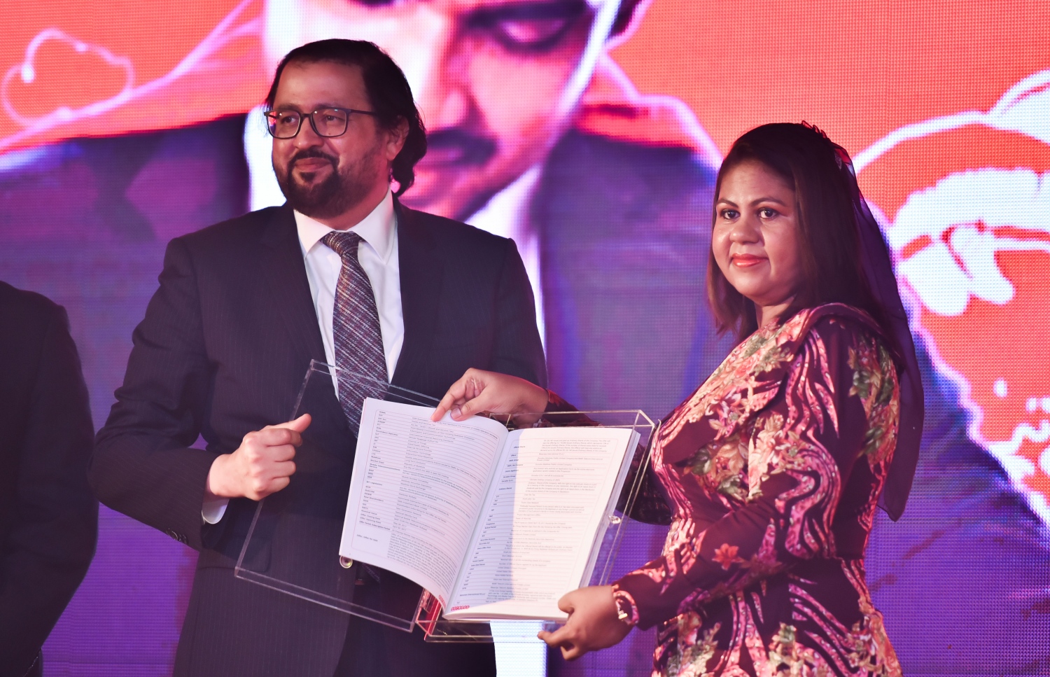 މާލެ: އޭޕްރީލް 19، 2017- އުރީދޫ އިން ހިއްސާ ވިއްކުން އިފްތިތާހުކުރުމުގެ ގޮތުން ބޭއްވި ރަސްމިއްޔާތުގައި، އެ ކުންފުނީގެ ޑެޕިއުޓީ ސީއީއޯ ޚާލިދު މުހައްމަދު އުރީދޫގެ ޕްރޮސްޕެކްޓަސް، އެމްއެމްއޭގެ ގަވަރުނަރު އަޒީމާ އާދަމް އަށް އަރުވަނީ.---މިހާރު ފޮޓޯ: ހުސެއިން ވަހީދު