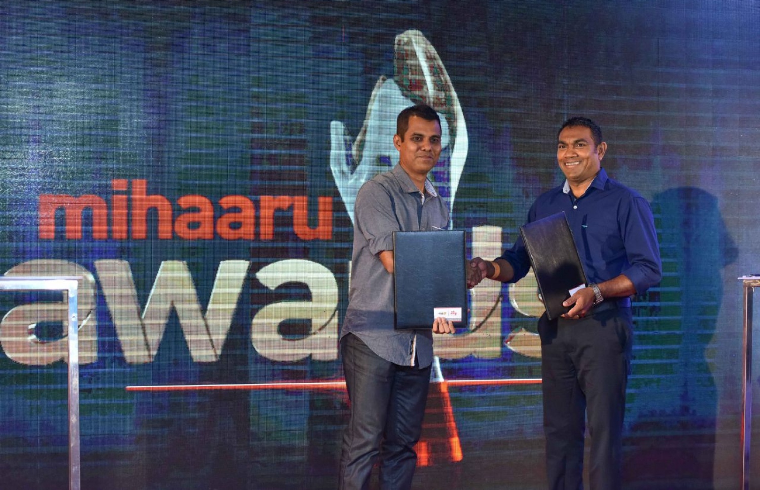 "މިހާރު އެވޯޑްސް" ފަރުމާކޮށް މާކެޓްކުރުމުގެ ޒިންމާ އުފުލާ ތިންކް އެޑްވަޓައިޒިންގެ ސީއީއޯ އަދީލް އިސްމާއިލް (ވ) އާއި މިހާރުގެ ސީއީއޯ ރިއްފަތު މުހައްމަދު އެއްބަސްވުން ބަދަލުކުރައްވަނީ. --ފޮޓޯ: ނިޝާން އަލީ/ މިހާރު