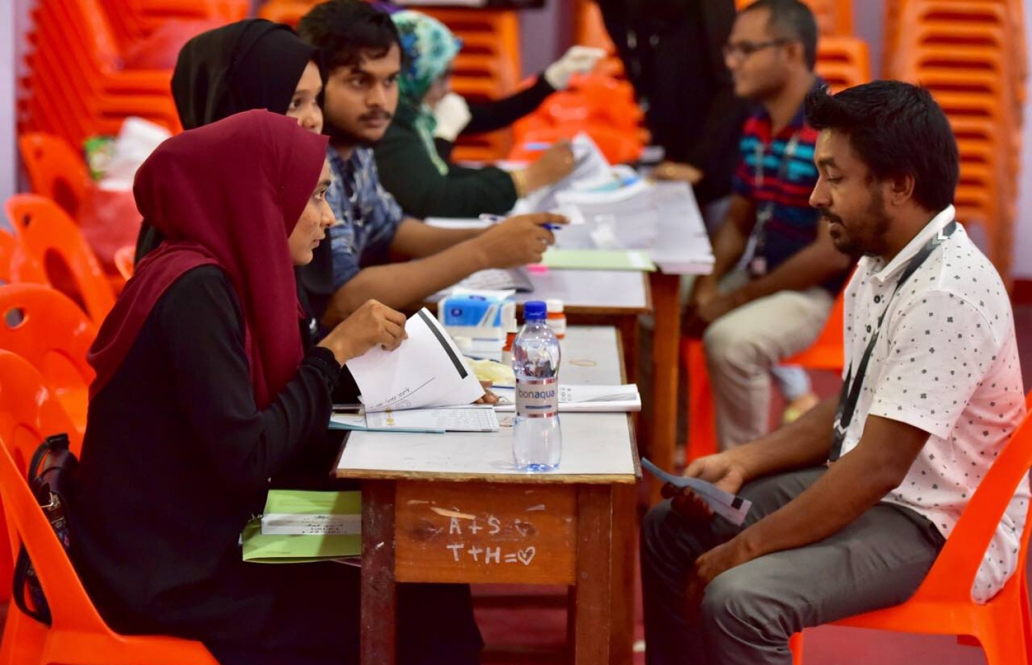 މާލެ: މޭ 6، 2017: ލޯކަލް ކައުންސިލް އިންތިހާބުގައި މީހަކު ވޯޓު ލުމަށް އޮފިޝަލުން މޭޒުކައިރީގައި މަޑުކޮށްލައިގެން.-- ފޮޓޯ: ނިޝާން އަލީ/ މިހާރު