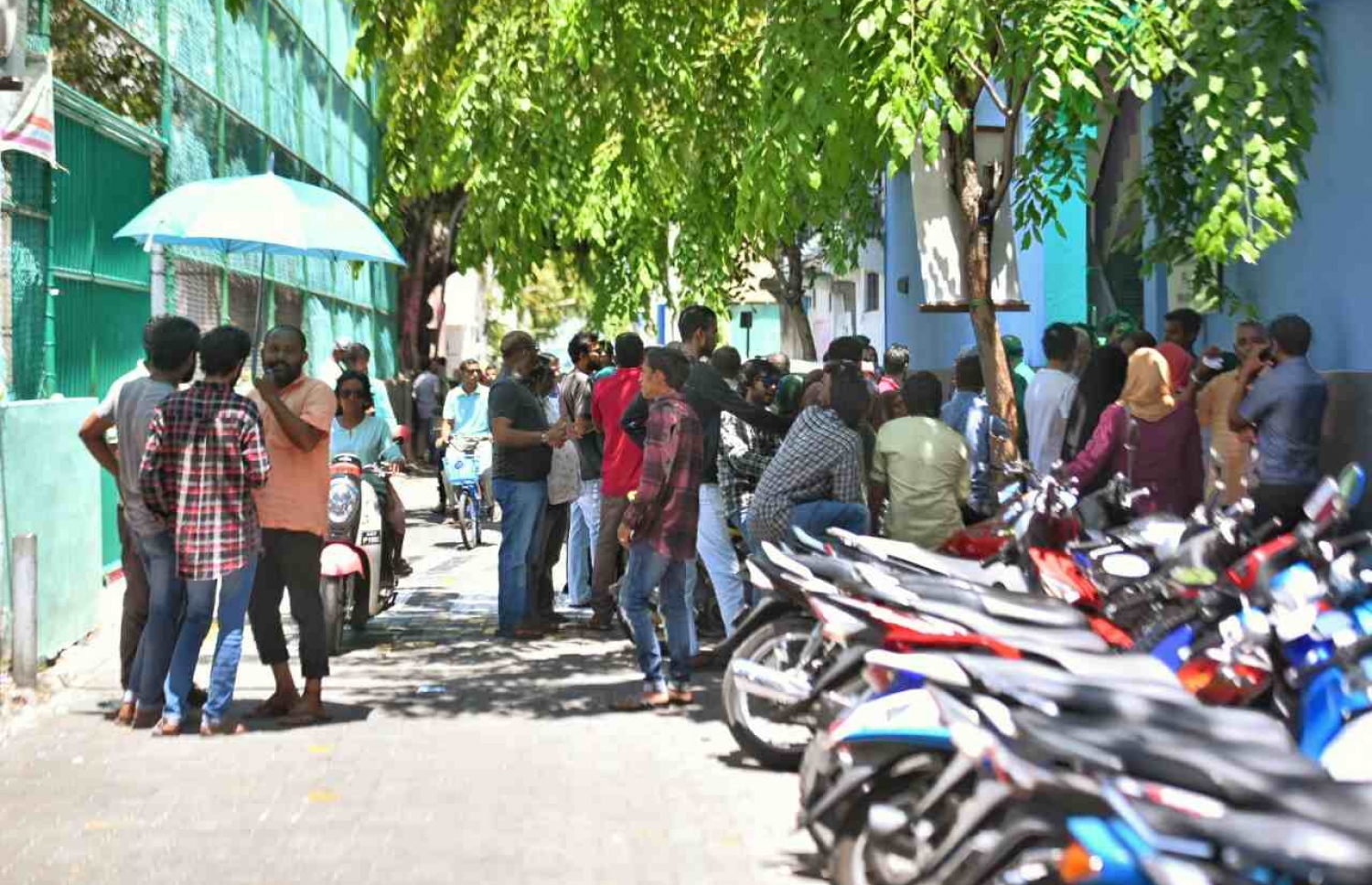 ކައުންސިލް އިންތިހާބުގައި ވޯޓު ލާން ގޮސް ތިބި ބަޔަކު ވޯޓިން ބޫތުގެ ބޭރުގައި މަޑުކޮށްލައިގެން -- ފޮޓޯ: ހުސެއިން ވަހީދު/ މިހާރު