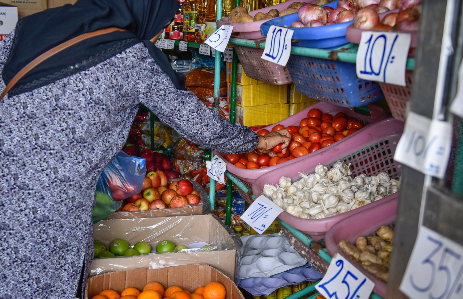 މާލެ: މޭ 17، 2017: ބާޒާރުމަތީގެ ފިހާރައަކުން މީހަކު ޓޮމާޓޯ ގަންނަނީ: ރޯދަމަސް ފެށެން ކައިރިވެފައިވާއިރު، ކެއުމަށް ބޭނުންކުރާ ގިނަ ބާވަތްތަކުގެ އަގު ވަނީ އުފުލިފައި.--- ފޮޓޯ: ނިޝާން އަލީ /މިހާރު