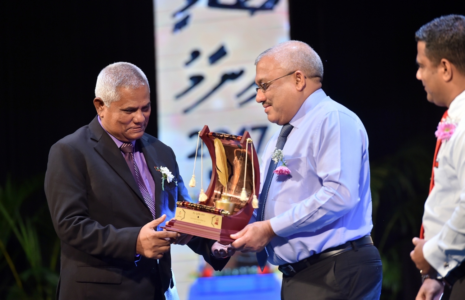 މާލެ: މޭ 16، 2017: ދިވެހި އަދަބިއްޔާތުގެ ދާއިރާ އިން ޅެންވެރިކަމުގެ ރޮނގުން ވ. ކަނދު، ރޯނުގޭ ހަސަން މަނިކަށް، ނައިބު ރައީސް ޖިހާދު އެވޯޑް ދެއްވަނީ: މިއީ ދިވެހި ބަސް ކުރިއެރުވުމަށް މަސައްކަތް ކުރަމުން އަންނަ ބޭފުޅުންނަށް ހިތްވަރު ދިނުމުގެ ގޮތުން ދިވެހި ބަހުގެ އެކަޑެމީން އަލަށް ތައާރަފުކުރި އެވޯޑެއް: މި ފަހަރު ހަތަރު ދާއިރާއަކުން ފަސް ބޭފުޅަކަށް އެވޯޑް ލިބިވަޑައިގެންނެވި.---ފޮޓޯ: ރައީސް އޮފީސް