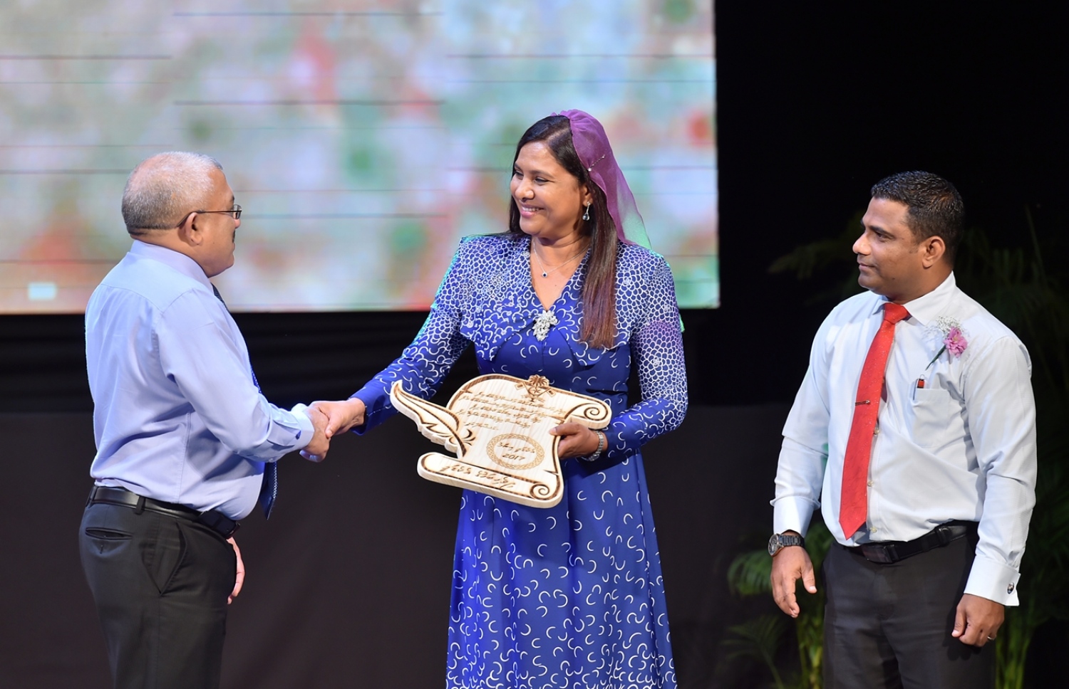 މާލެ: މޭ 16، 2017: ދިވެހި ބަސް ކުރިއެރުވުމަށް މަސައްކަތް ކުރަމުން އަންނަ ބޭފުޅުންނަށް ހިތްވަރު ދިނުމުގެ ގޮތުން ދިވެހި ބަހުގެ އެކަޑެމީން ތައާރަފުކުރި އެވޯޑް ދިނުމަށް އޮލިމްޕަހުގައި ބޭއްވި ރަސްމިއްޔާތުގައި ނައިބު ރައީސް އަބްދުﷲ ޖިހާދާއި އެޑިއުކޭޝަން މިނިސްޓަރު ޑރ. އައިޝަތު ޝިހާމް ސަލާމް ކުރައްވަނީ: ހަތަރު ދާއިރާއަކުން ފަސް ބޭފުޅަކަށް މިފަހަރު އެވޯޑް ލިބިވަޑައިގެންނެވި.---ފޮޓޯ: ރައީސް އޮފީސް