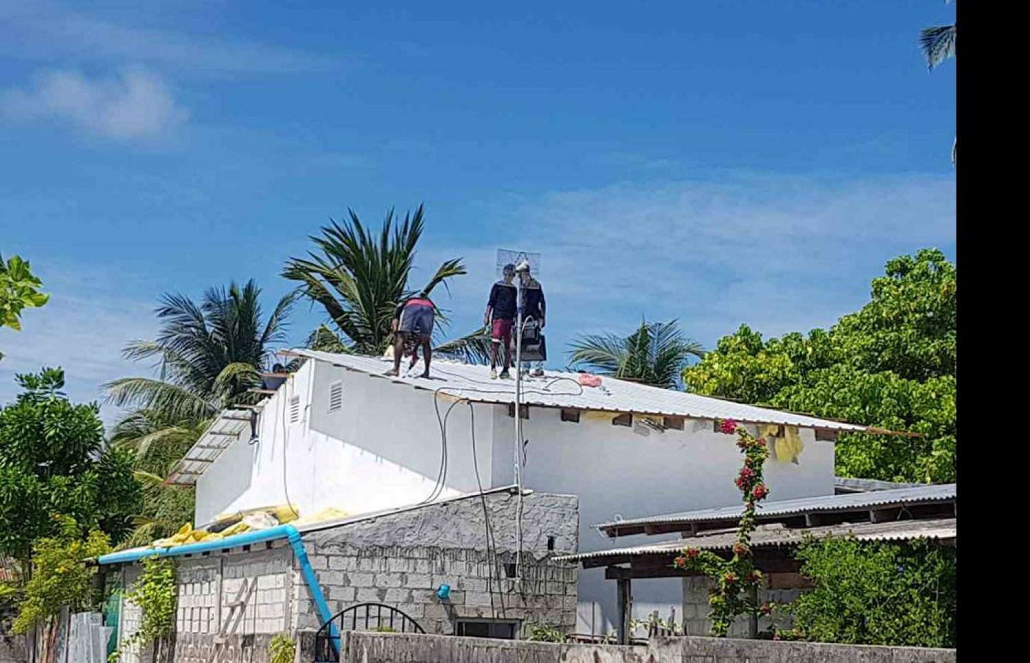 ނަގޫރޯޅީގައި ފުރާޅު އެއްލާލި ގެއެއްގެ ފުރާޅު މަރާމާތު ކުރަނީ. ފޮޓޯ: ކިޔުންތެރިއެއް.