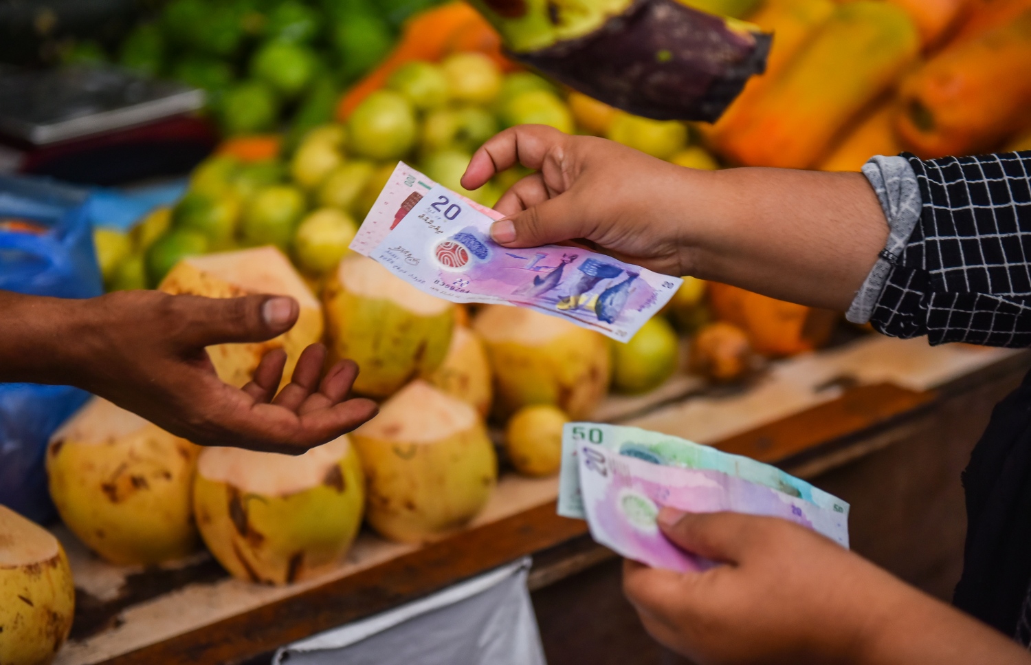 މާލޭގެ މާރުކޭޓު ސަރަހައްދުގައި މީހަކު ވިޔަފާރީގެ މުއާމަލާތެއް ކުރަނީ .--- މިހާރު ފޮޓޯ: ހުސައިން ވަހީދު