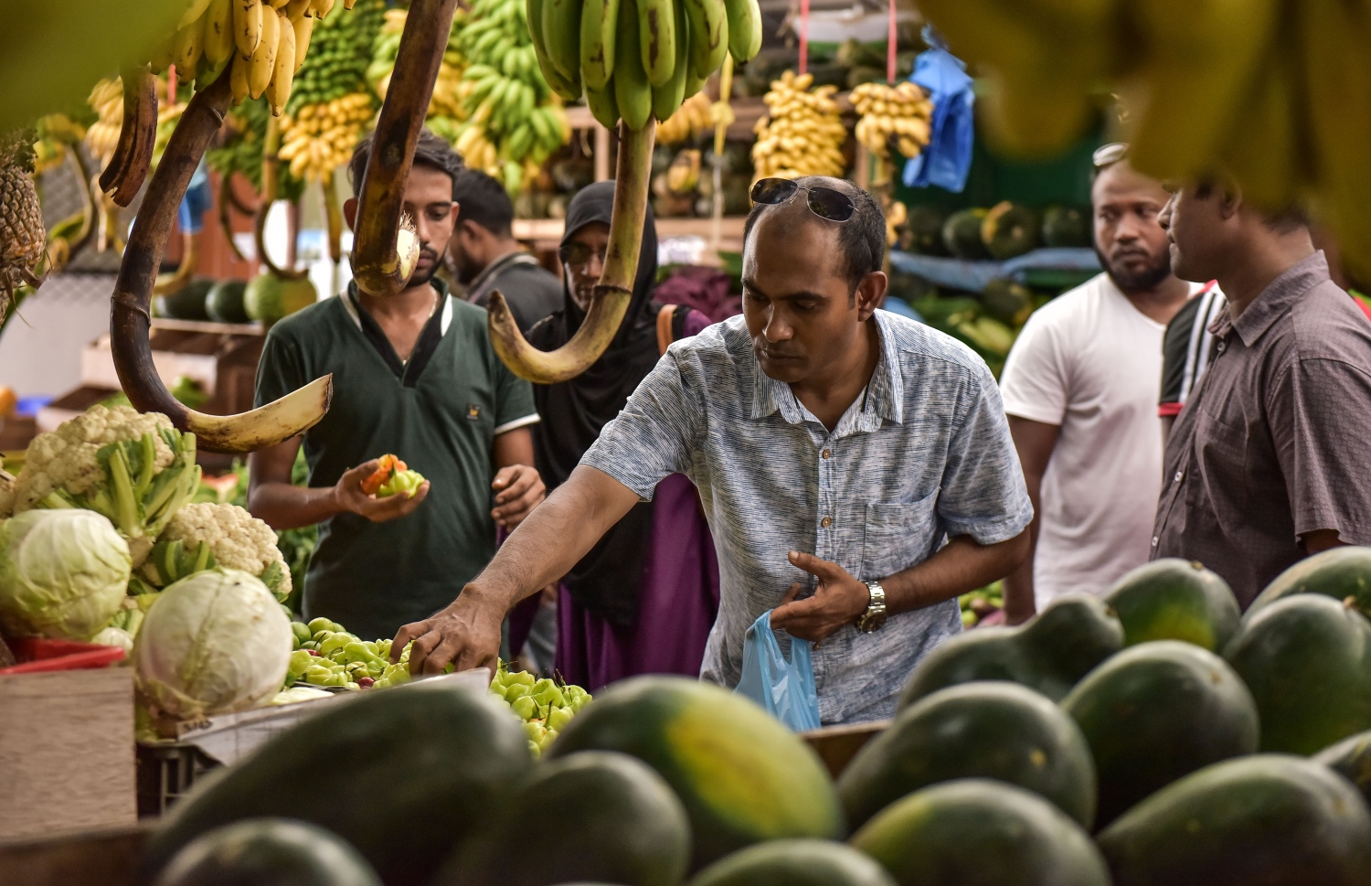 ދަތުރުވެރިންގެ މާރުކޭޓުގެ ގޮޅިއެއްގައި ވިއްކަން ބަހައްޓާފައި ހުރި ކަރާތަކެއް މީހަކު ބަލަނީ -- ފޮޓޯ: ނިޝާން އަލީ /މިހާރު