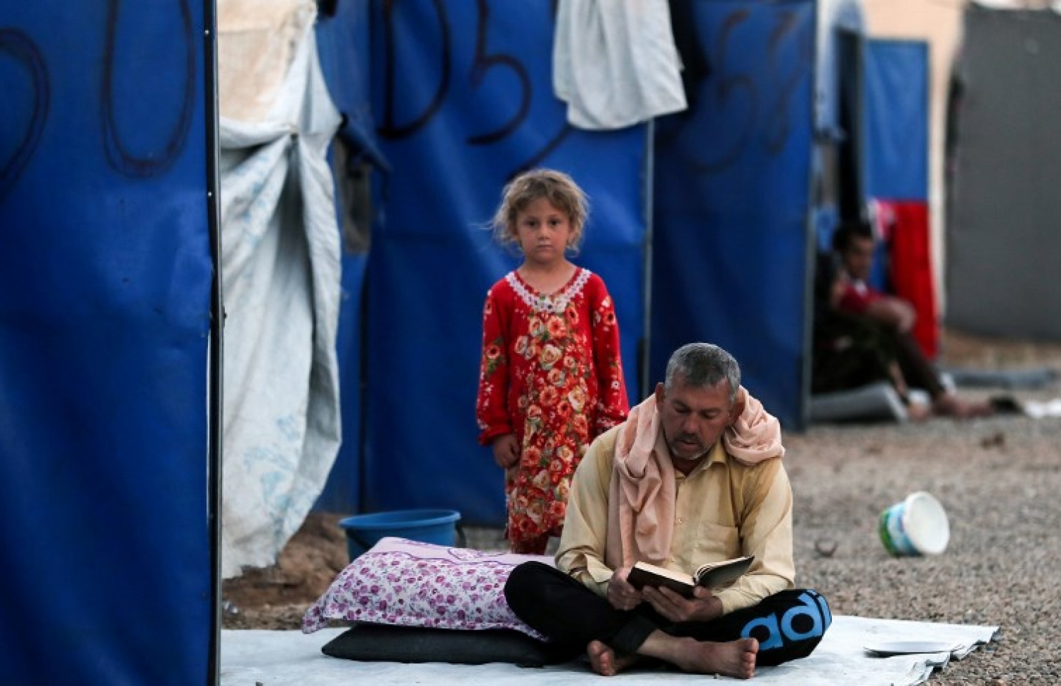 އިރާގުގެ ރެފިއުޖީ ކޭމްޕެއްގައި މީހަކު ގުރުއާން ކިޔަވަނީ. --ފޮޓޯ:އޭއެފްޕީ