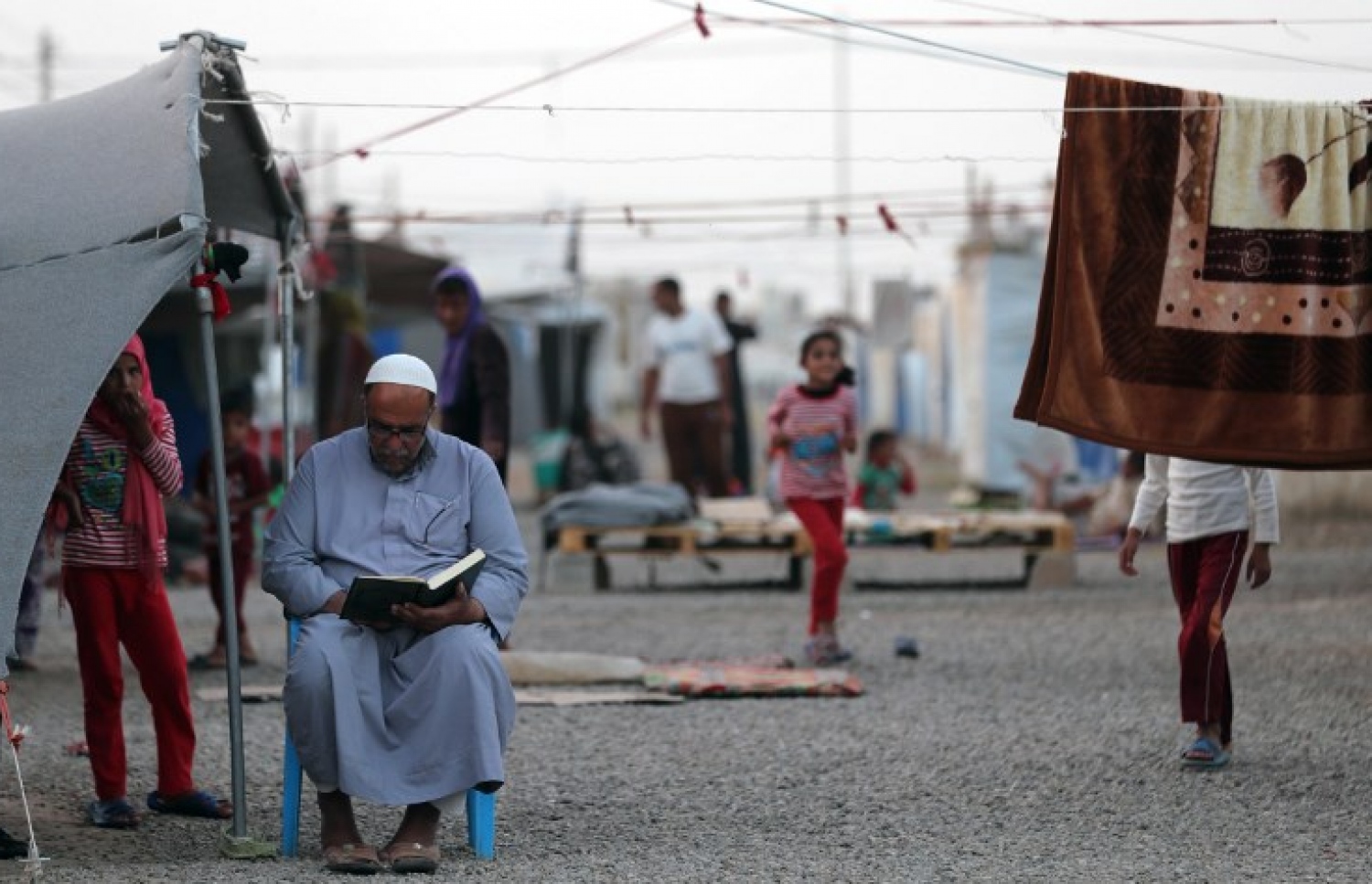 އިރާގުގެ ރެފިއުޖީ ކޭމްޕެެއްގައި މީހަކު ގުރުއާން ކިޔަވަނީ. --ފޮޓޯ:އޭއެފްޕީ