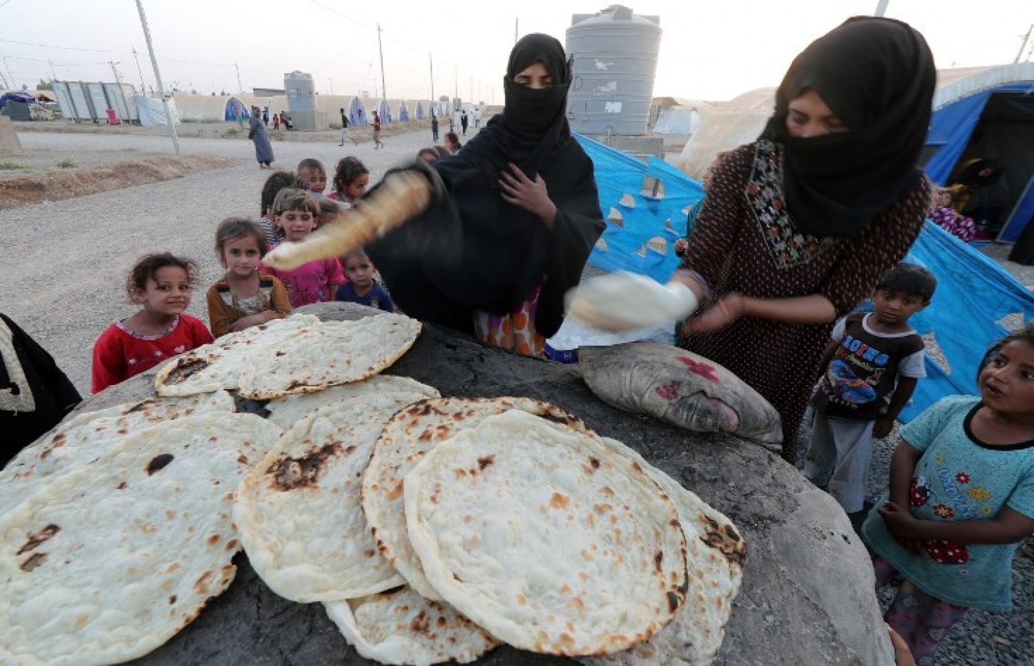 އިރާގުގެ މޫސަލްގެ ރެފިއުޖީ ކޭމްޕެއްގައި ބަޔަކު ރޮށި ހިފަނީ. --ފޮޓޯ:އޭއެފްޕީ