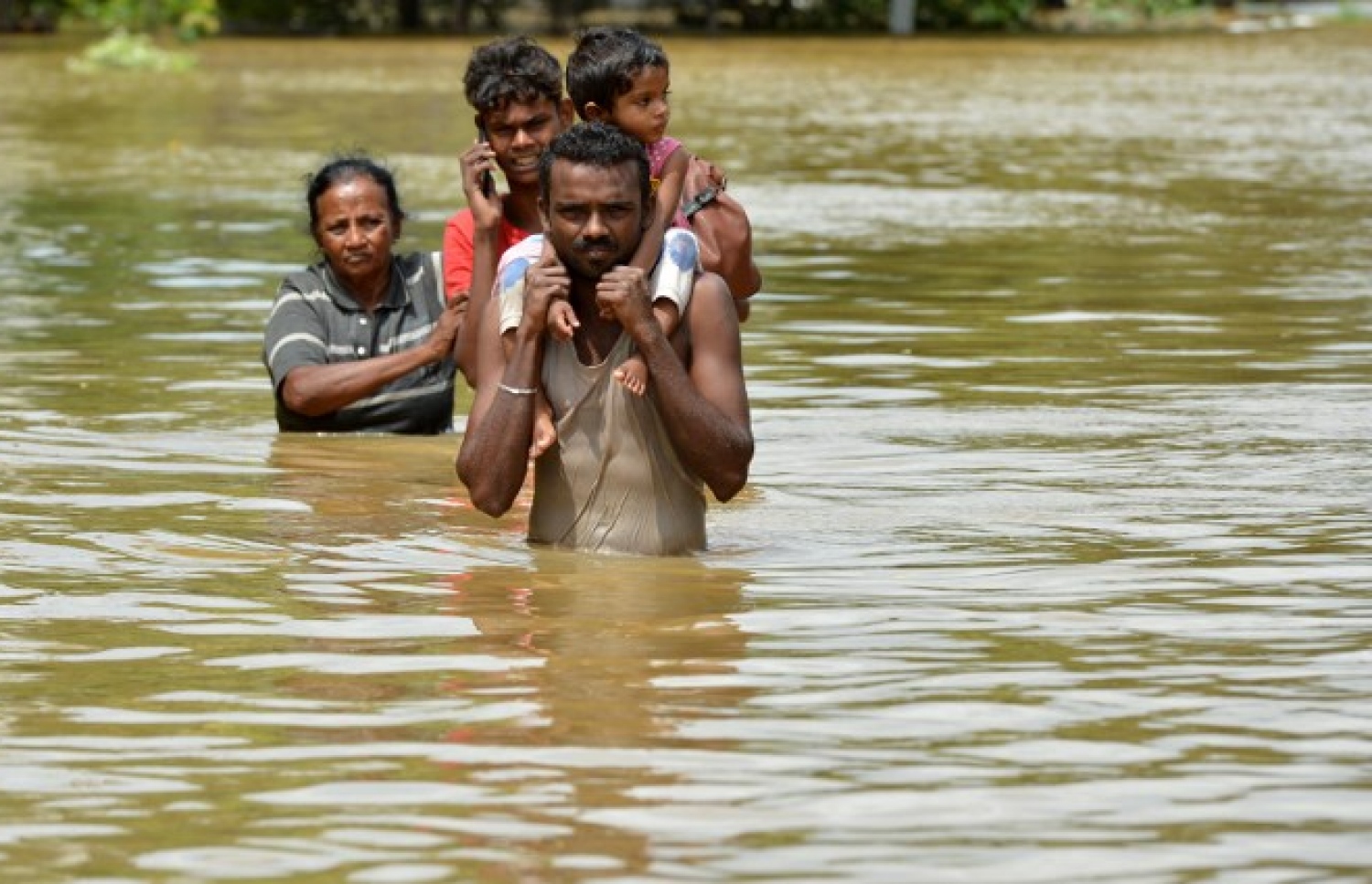 ސްރީ ލަންކާ އަށް ބޯކޮށް ވާރޭ ވެހުމުގެ ސަބަބުން ފެންބޮޑުވެފައިވާ ކޮލަމްބޯގެ ކަޑުވެލައިގެ ފެންގަނޑު ތެރޭން އާއިލާއެއްގެ ބަޔަކު ދަނީ. --ފޮޓޯ:އޭއެފްޕީ