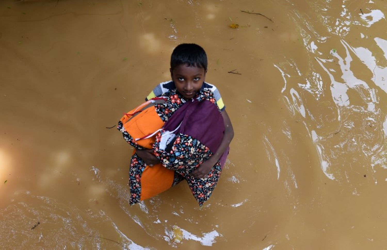 ސްރީ ލަންކާގެ ފެންބޮޑުވެފައިވާ ކެލަނިޔާގައި ފެންގަނޑު ތެރޭ ކުޑަ ކުއްޖަކު ބާލީސްތައް ހިފައިގެން ދަނީ. --ފޮޓޯ:އޭއެފްޕީ