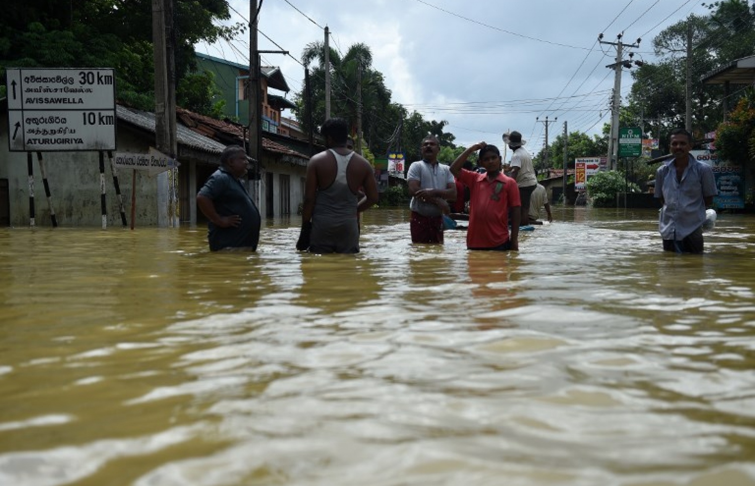 ވެރިރަށް ކޮލަމްބޯގައި ފެންބޮޑުވެފައިވާ ކަޑުވެލާގެ މަގެއްގައި ބަޔަކު ހިނގާފައި ދަނީ. --ފޮޓޯ:އޭއެފްޕީ