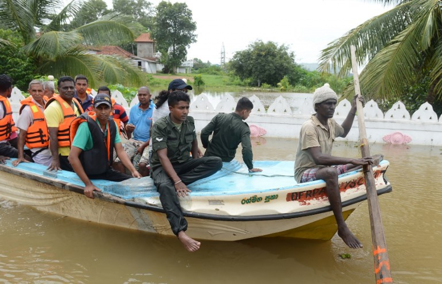 ސްރީ ލަންކާގައި ފެންބޮޑުވެފައިވާ ސަރަހައްދަކުން ބަޔަކު ކުޑަ ބޯޓެއްގައި ގެންދަނީ. --ފޮޓޯ:އޭއެފްޕީ