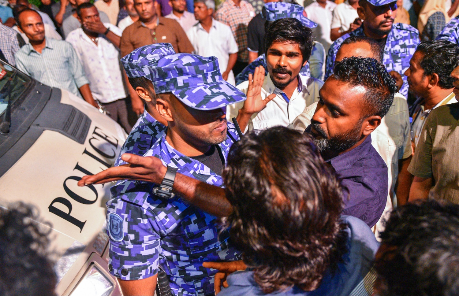 މާލެ: ޖޫން 9، 2017- މެމްބަރު މަހްލޫފު ޖަލުން މިނިވަންވުމާ ގުޅިގެން އޭނާ އަށް ޓަކައި އިދިކޮޅު ފަރާތްތަކުން އެމްޑީޕީގެ ހަރުގޭގައި ބޭއްވި ޖަލްސާ ބެލުމަށް މަގުމަތީގައި ތިބި ބަޔަކާއި ފުލުހުންނާ ދެމެދު ކުރިމަތިލުމެއް ހިނގަނީ: އެ ސަރަހައްދުން މީހުން ފޮނުވާލުމަށް ފުލުހުން މަސައްކަތް ކުރި.---މިހާރު ފޮޓޯ: ހުސެއިން ވަހީދު