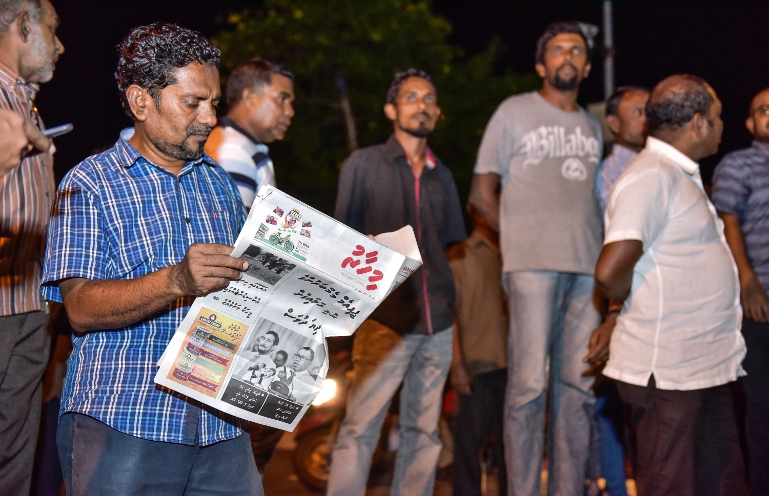 މާލެ: ޖޫން 14، 2017- ކުރީގެ ރައީސް މައުމޫން ތިން މަހެއްހާ ދުވަހު ރާއްޖެ އިން ބޭރުގައި އުޅުއްވުމަށް ފަހު، އެނބުރި ވަޑައިގަންނަވާތީ އެމަނިކުފާނަށް މަރުހަބާ ދެންނެވުމަށް އެއްވި ބައެއް މީހުން އެމްއެމްއޭ ކައިރީގައި މަޑުކޮށްލައިގެން ތިބިއިރު، އެކަކު "މިހާރު" ނޫސް ކިޔަނީ.---މިހާރު ފޮޓޯ: ނިޝާން އަލީ