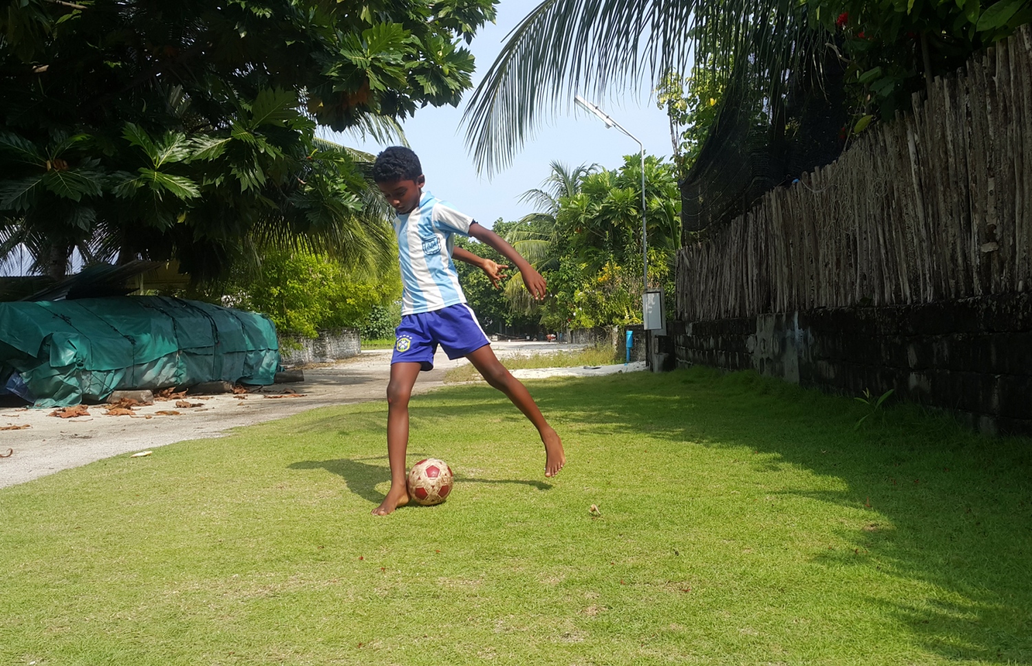 ފެހެންދޫ ކުއްޖަކު އޭނާގެ ގޭދޮށުގައި އޮތް ވިނަގަނޑެއްގައި ފުޓްބޯޅަ ކުޅެނީ. ދިރިއުޅުމުގެ ވަސީލަތްތައް ހުރި ރަށަކަށް ބަދަލުވާން މި ރަށުގެ މީހުން ބޭނުންވޭ. ފޮޓޯ: އަހްމަދު އަބްދުﷲ ސައީދު/މިހާރު