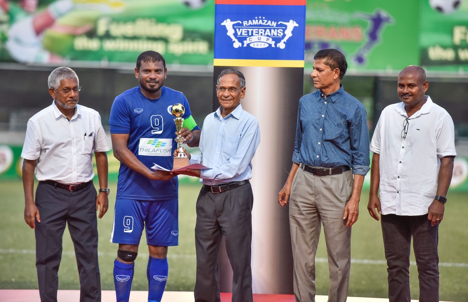 ފައިނަލް މެޗުގެ ޝަރަފްވެރި މެހުމާން ކުރީގެ ކުޅިވަރާ ބެހޭ މިނިސްޓަރު ޒާހިރު ހުސެއިން (ކ.3) އަށް މުބާރާތުގެ އެންމެ ގިނަ ލަނޑު ޖެހި ނިއުގެ އައްޔަ (ވ.2)އާ ޓްރޮފާ ހަވާލުކުރަނީ.-- ފޮޓޯ: ނިޝާން އަލީ/ މިހާރު