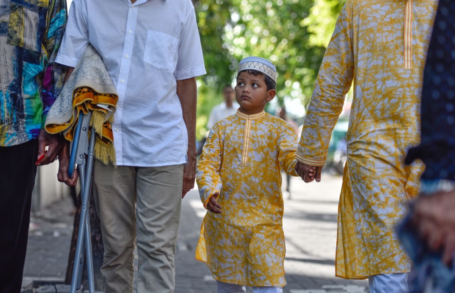 މާލެ: ޖޫން 25، 2017- މާފަންނު ސްޓޭޑިއަމްގައި ބޮޑު ޖަމާއަތުގައި ކުރި މި އަހަރުގެ ފިތުރު އީދު ނަމާދަށް ކުޑަކުއްޖަކު ގޮވައިގެން މީހަކު ދަނީ.---މިހާރު ފޮޓޯ: ނިޝާން އަލީ