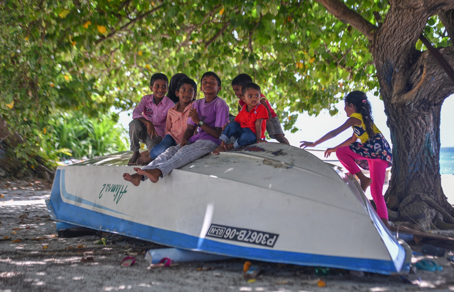 ރ.ކިނޮޅަސް: ޖޫން 28، 2017- ކިނޮޅަހު އަތިރިމަތީގައި އެހެލާފައި އޮތް ޑިންގީއެއްގެ މައްޗަށް ކުޑަ ކުދިންތަކެއް އަރައިގެން ކުޅެނީ.---މިހާރު ފޮޓޯ: ހުސައިން ވަހީދު