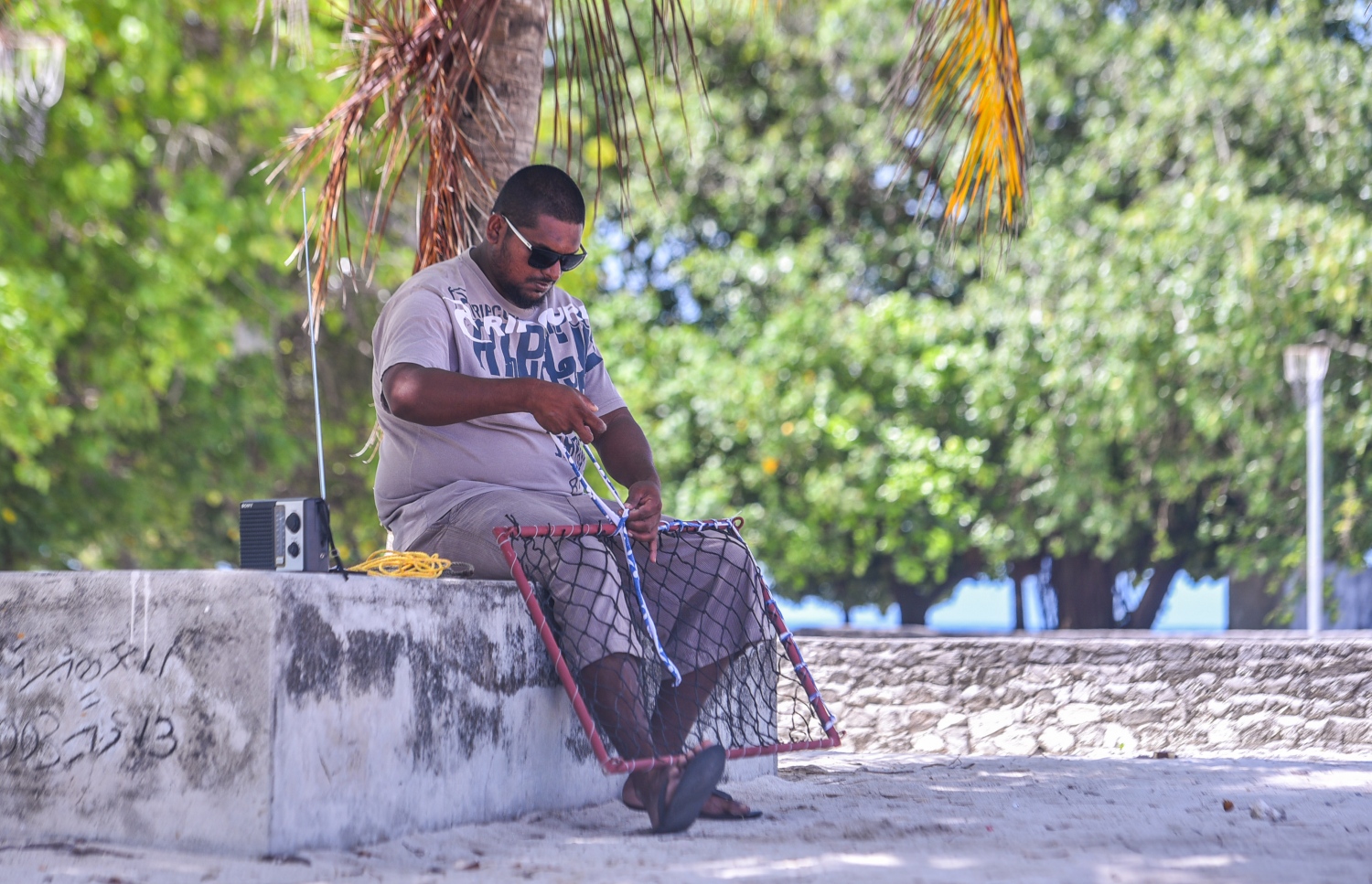 ރ.ކިނޮޅަސް: ޖޫން 28، 2017- ކިނޮޅަހު ބޭރުމަގުގައި ހުރި ހޮޅުއަށްޓެއްގައި މީހަކު ރޭޑިއޯ އަޑުއަހަން އިނދެގެން ޖޯއްޔެއް ގަތަނީ..---މިހާރު ފޮޓޯ: ހުސައިން ވަހީދު