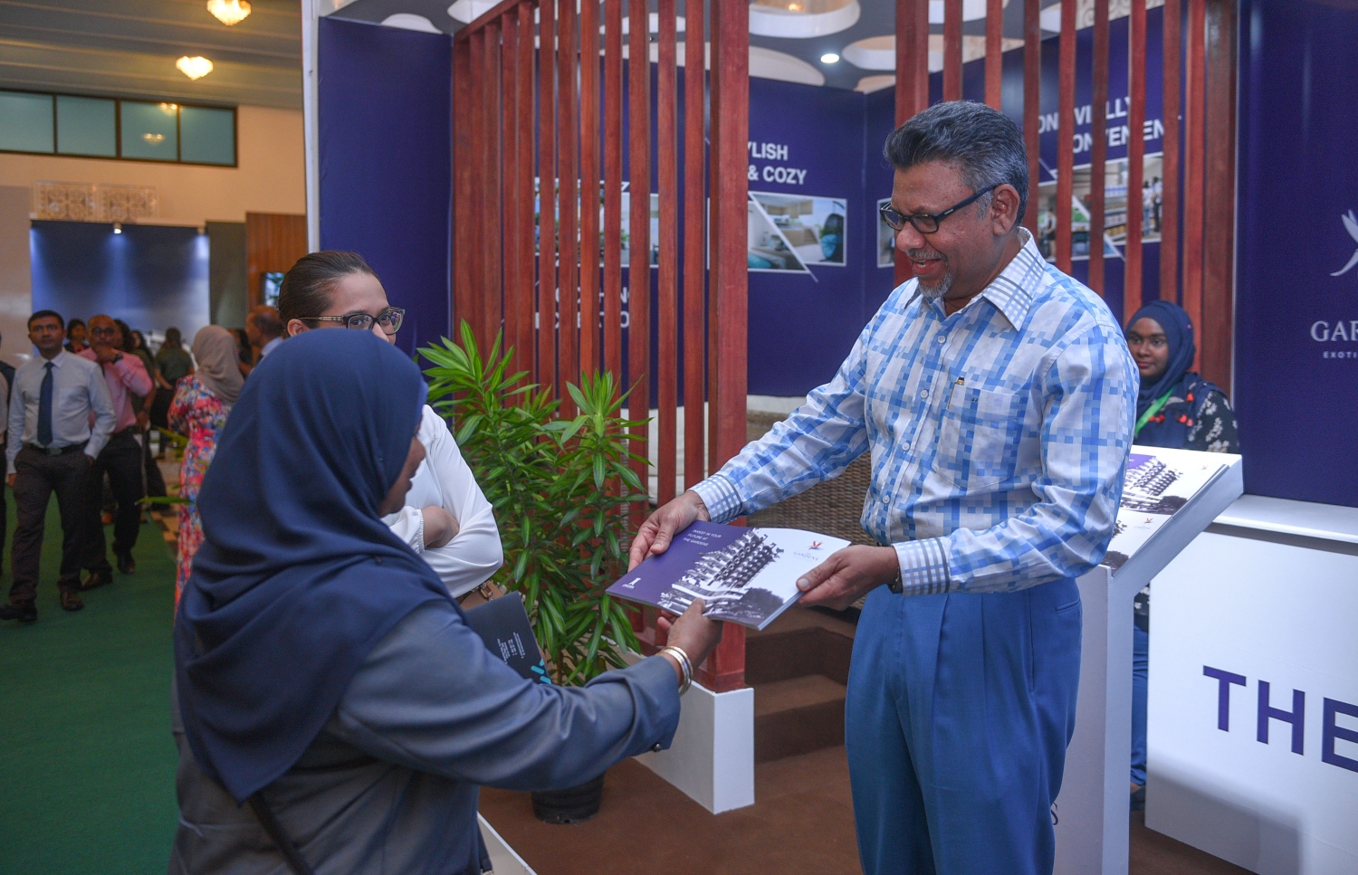 މާލެ: ޖުލައި 6، 2017- ގެދޮރުވެރިކަމަށް ބޭނުންވާ ފައިސާ ހޯދޭނެ ގޮތްތަކާ ބެހޭ ގޮތުން އެމްއެމްއޭ އާއި އެޗްޑީސީ ގުޅިގެން ދަރުބާރުގޭގައި ފެށި މި އަހަރުގެ މޯލްޑިވްސް ފައިނޭންޝަލް އެކްސްޕޯގައި ހުރި ޖައުސާ ކޮންސްޓްރަކްޝަންގެ ސްޓޯލަކުން، އެ ކުންފުނީގެ މަސައްކަތްތަކާ ގުޅޭ މައުލޫމާތު ހިމެނޭ ލީފްލެޓެއް ޖައުސާގެ ޗެއާމަން ޖައުފަރު މީހަކަށް ދެއްވަނީ.---މިހާރު ފޮޓޯ: ހުސެއިން ވަހީދު