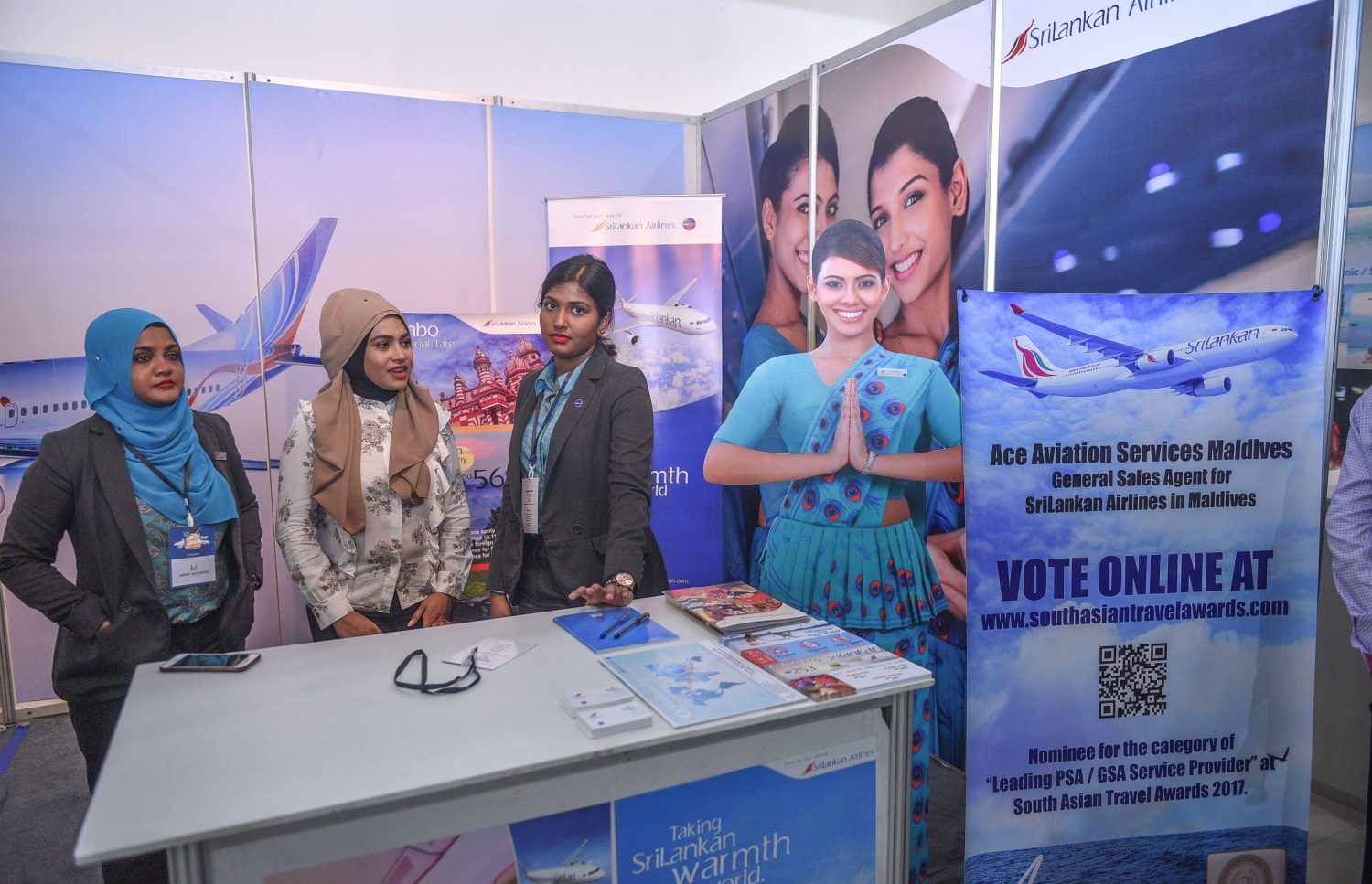 މާލެ: ޖުލައި 6، 2017- ދަތުރުފަތުރުކުރުމާ ބެހޭ މައުލޫމާތު ދިވެހިންނާއި ރާއްޖޭގައި ވަޒީފާ އަދާކުރާ ބޭރު މީހުންނަށް ފޯރުކޮށްދިނުމަށް ހައިރައިސް އިން އިންތިޒާމުކޮށްގެން ބާއްވާ މި އަހަރުގެ ވެކޭޝަންސް އެކްސްޕޯގައި ހުރި ސްރީލަންކަން އެއާލައިންސްގެ މުވައްޒަފުންތަކެއް އެ ސްޓޯލްގައި މަޑުކޮށްލައިގެން: އާޓް ގެލެރީގައި ކުރިއަށް ގެންދާ މި އެކްސްޕޯ އޮންނާނީ އަންނަ ހޮނިހިރުދުވަހުގެ ނިޔަލަށް.---މިހާރު ފޮޓޯ: ހުސެއިން ވަހީދު