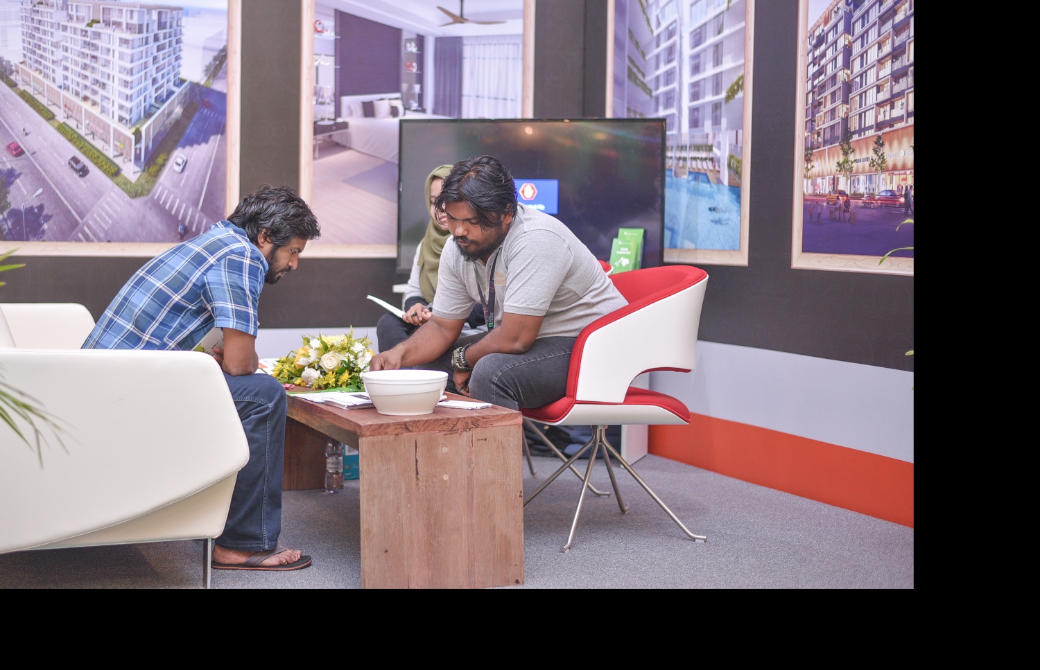 ހުޅުމާލޭގައި އަލަށް ހަދާ އެޕާޓްމަންޓްތަކަކާ ބެހޭ މައުލޫމާތު އެކްސްޕޯގެ ސްޓޯލަކުން މީހަކަށް ކިޔައިދެނީ --ފޮޓޯ: ހުސެއިން ވަހީދު /މިހާރު