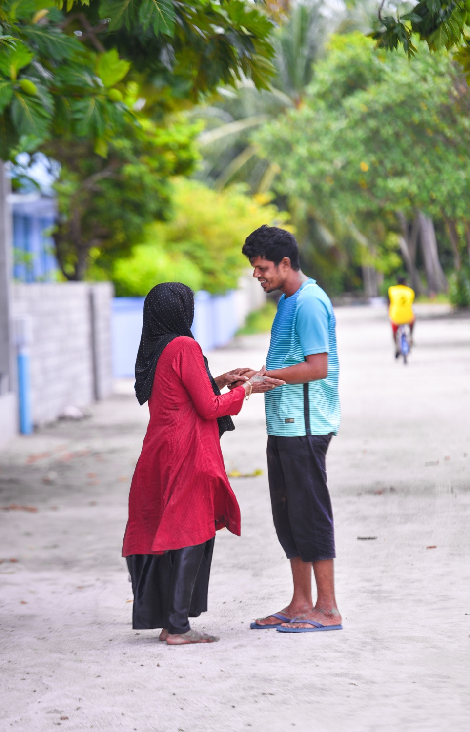 ރ.ފައިނު: ޖުލައި 7، 2017- މުސްކުޅި އަންހެނަކާ އެކު މީހަކު މަގުމަތީގައި މަޑުކޮށްލައިގެން ހުރެ ވާހަކަ ދައްކާލަނީ. --މިހާރު ފޮޓޯ: ހުސައިން ވަހީދު