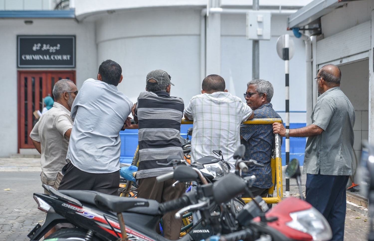 މާލެ: ޖުލައި 9، 2017- ފުލުހުންގެ ތަހުގީގެއްގައި ފޯނެއް ހުޅުވައި ނުދިން މައްސަލާގައި ކިނބިދޫ ދާއިރާގެ މެމްބަރު އަބްދުﷲ ރިޔާޒަށް ހުކުމް އިއްވުމަށްޓަކައި އޭނާ ކްރިމިނަލް ކޯޓަށް ހާޒިރުކޮށްފައިވާއިރު، ރިޔާޒްގެ އިންތިޒާރުގައި ބައެއް މީހުން ކޯޓުން ބޭރުގައި މަޑުކޮށްލައިގެން: ރިޔާޒްގެ މައްޗަށް އެ ދައުވާ ސާބިތުނުވާ ކަމަށް ކޯޓުން ނިންމި.---މިހާރު ފޮޓޯ: ހުސެއިން ވަހީދު