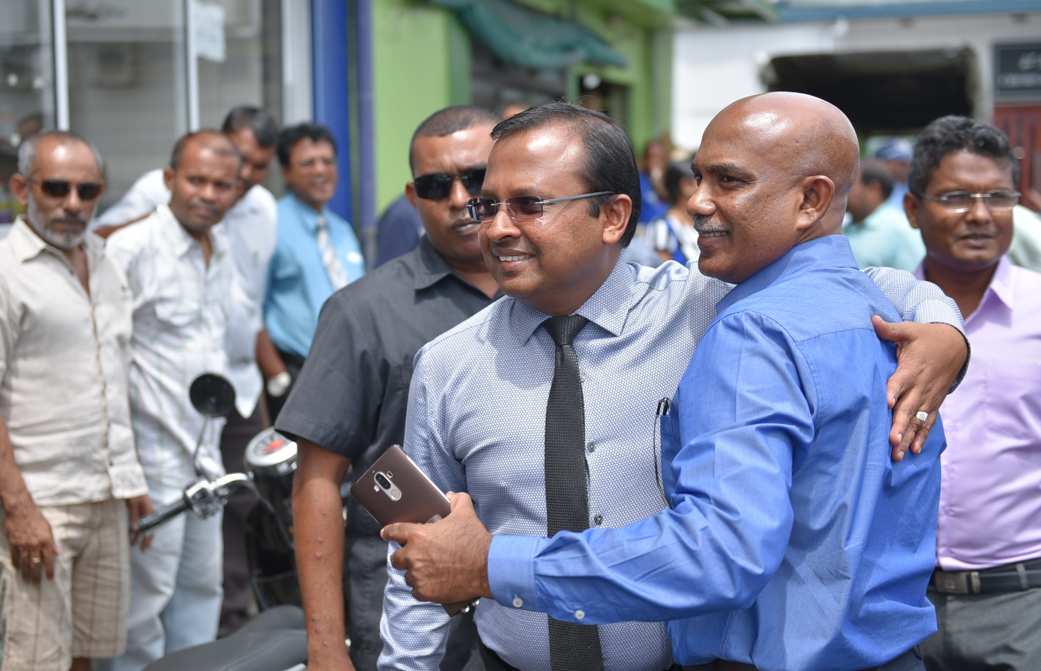 މާލެ: ޖުލައި 9، 2017- ފުލުހުންގެ ތަހުގީގެއްގައި ފޯނެއް ހުޅުވައި ނުދިން މައްސަލާގައި ކިނބިދޫ ދާއިރާގެ މެމްބަރު އަބްދުﷲ ރިޔާޒަށް ކުރި ދައުވާ ސާބިތުނުވާ ކަމަށް ކްރިމިނަލް ކޯޓުން ހުކުމް ކުރުމުން، ކޯޓުން ނުކުމެވަޑައިގެން، ޖުމްހޫރީ ޕާޓީގެ ސެކްރެޓަރީ އަހުމަދު ސަމީރާ އެކު ރިޔާޒް އެކަން ސެލެބްރޭޓް ކުރަނީ.---މިހާރު ފޮޓޯ: ހުސެއިން ވަހީދު