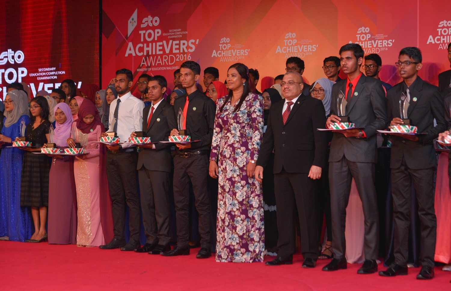 މާލެ: ޖުލައި 13، 2017- މިދިޔަ އަހަރުގެ އޯ ލެވެލް އިމްތިހާނުގެ ގަދަ 10 ގައި ހިމެނުނު ދަރިވަރުންނަށް އިނާމު ދިނުމަށް ބޭއްވި ހަފުލާގައި އިނާމު ލިބުނު ބައެއް ދަރިވަރުންނާ އެކު ނައިބު ރައީސް ޖިހާދާއި އެޑިއުކޭޝަން މިނިސްޓަރު އައިޝަތު ޝިހާމް ފޮޓޯއަކަށް ހުއްޓިވަޑައިގެން: އިނާމާ އެކު ސްޓޭޖްމަތީގައި: މި އިމްތިހާނުގައި ދުނިޔޭގެ ފެންވަރުގައި އެކި މާއްދާތަކުން ގަދަ 10 ގައި ރާއްޖޭގެ 48 ދަރިވަރަކު ވެސް ހިމެނުނު. އަދި ރާއްޖޭގެ ގަދަ 10 ގައި 589 ދަރިވަރަކަށް ހިމެނިފައިވޭ.---މިހާރު ފޮޓޯތައް: ހުސެއިން ވަހީދު