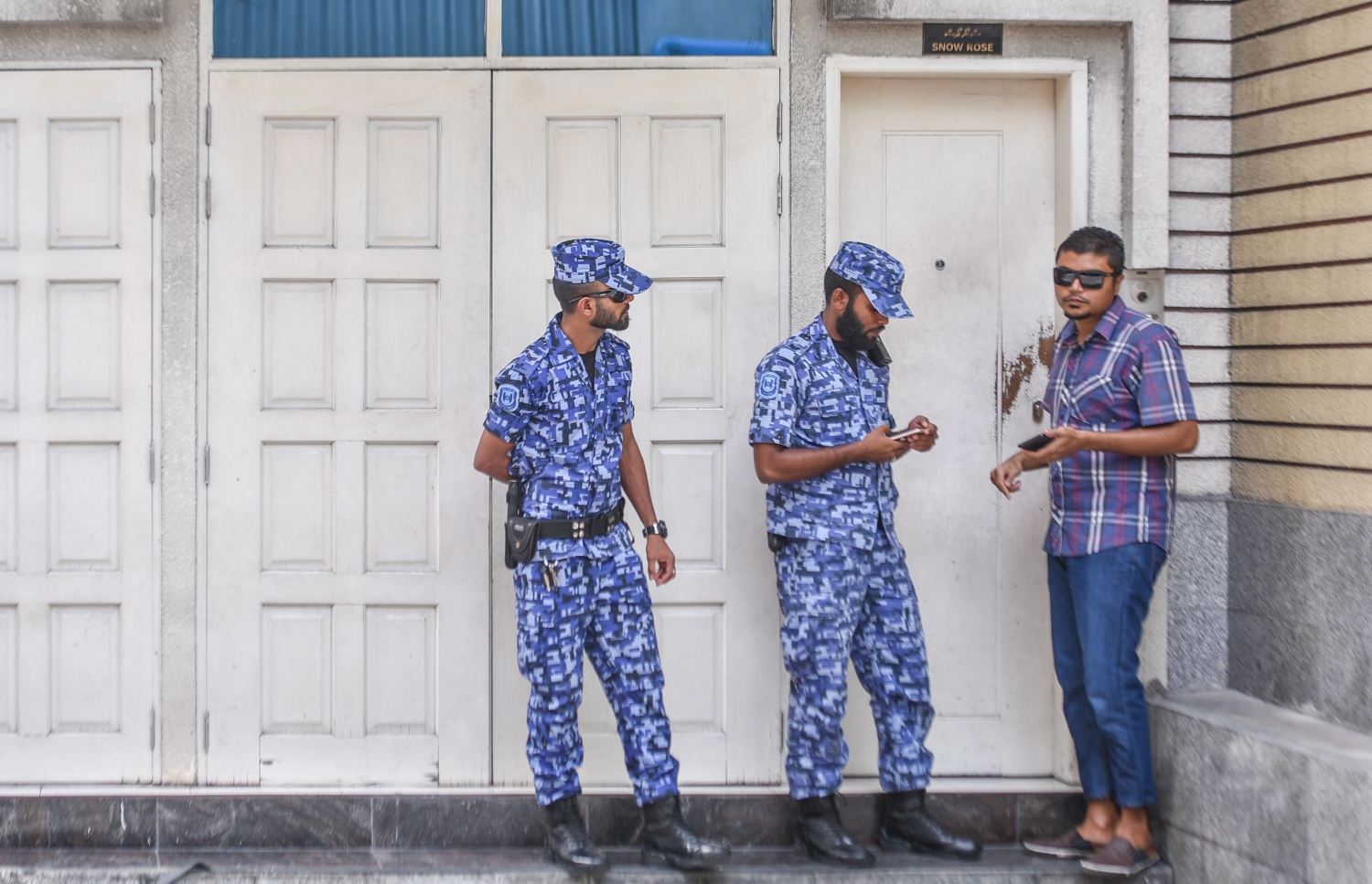 ޖުލައި 18، 2017- ކުރީގެ ރައީސް މައުމޫންގެ ދަރިކަލުން އަދި ދިއްގަރު ދާއިރާގެ މެމްބަރު ފާރިސް މައުމޫން މ. ސްނޯ ރޯޒްގައި ދިރިއުޅުއްވާ އެޕާޓްމަންޓް ފުލުހުން ކޯޓު އަމުރެއްގެ ދަށުން ބަލައި ފާސްކުރާއިރު، އެ ގޭގެ ދޮރުމަތީގައި ފުލުހުން ހަރަކާތްތެރިވަނީ: ފުލުހުން ފަހުން ވަނީ ކޯޓު އަމުރެއްގެ ދަށުން ފާރިސް ހައްޔަރުކޮށްފައި.---މިހާރު ފޮޓޯ: ހުސެއިން ވަހީދު