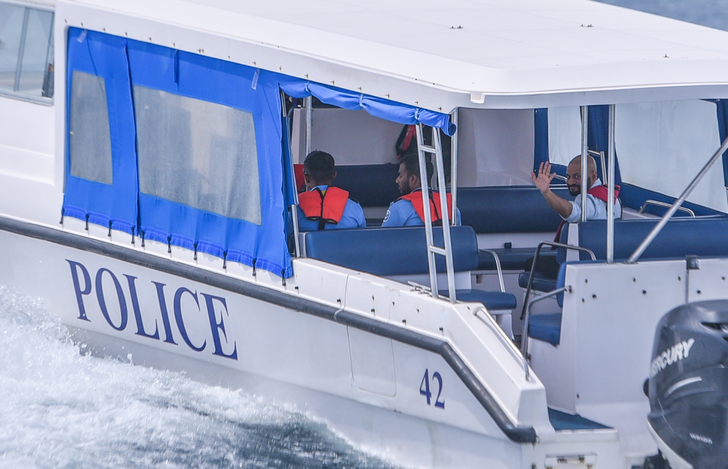 ޖުލައި 18، 2017- ކުރީގެ ރައީސް މައުމޫންގެ ދަރިކަލުން އަދި ދިއްގަރު ދާއިރާގެ މެމްބަރު ފާރިސް މައުމޫން ހައްޔަރުކޮށްގެން، ފުލުހުންގެ ލޯންޗެއްގައި ދޫނިދު އަށް ގެންދާއިރު، އޭނާގެ ސަޕޯޓަރުންނާ އަތުން އިޝާރާތްކޮށް ސަލާމް ކުރައްވަނީ.---މިހާރު ފޮޓޯ: ހުސެއިން ވަހީދު