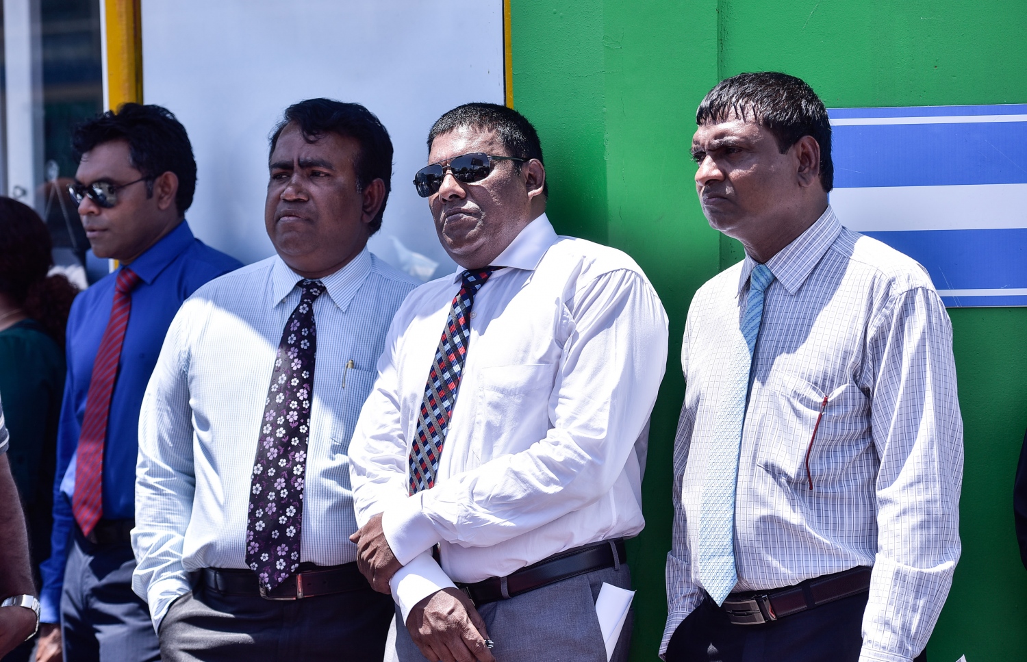 މާލެ: ޖުލައި 23، 2017- ރައްޔިތުންގެ މަޖިލީހުގެ ދިއްގަރު ދާއިރާގެ މެމްބަރު ފާރިސް މައުމޫން ޕީޕީއެމްގެ ދިދަ އާއި ލޯގޯ ގަވާއިދާ ޚިލާފަށް ބޭނުންކުރި ކަމަށް ބުނެ އޭނާގެ މައްޗަށް ކުރާ ދައުވާއާ ގުޅިގެން މިއަދު ކްރިމިނަލް ކޯޓުގައި އަޑުއެހުން ކުރިއަށް ގެންދިޔައިރު، އިދިކޮޅު ބައެއް މެމްބަރުން ކޯޓުން ބޭރުގައި.---މިހާރު ފޮޓޯ: ހުސެއިން ވަހީދު