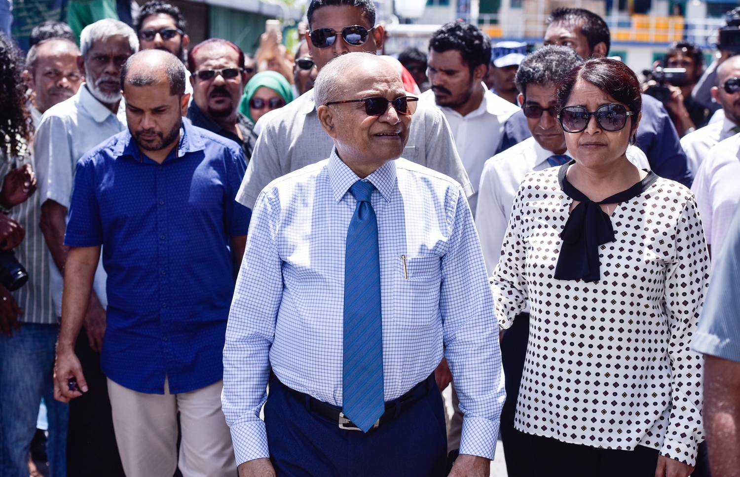 މާލެ: ޖުލައި 23، 2017- ރައްޔިތުންގެ މަޖިލީހުގެ ދިއްގަރު ދާއިރާގެ މެމްބަރު ފާރިސް މައުމޫން ޕީޕީއެމްގެ ދިދަ އާއި ލޯގޯ ގަވާއިދާ ޚިލާފަށް ބޭނުންކުރި ކަމަށް ބުނެ އޭނާގެ މައްޗަށް ކުރާ ދައުވާއާ ގުޅިގެން މިއަދު ކްރިމިނަލް ކޯޓުގައި ބޭއްވި އިބްތިދާއީ އަޑުއެހުމަށް ފާރިސްގެ ބައްޕާފުޅު އަދި ކުރީގެ ރައީސް މައުމޫން ވަޑައިގަތުމަށް ފަހު ސަޕޯޓަރުން ކައިރިއަށް ވަޑައިގަންނަވަނީ.---މިހާރު ފޮޓޯ: ހުސެއިން ވަހީދު